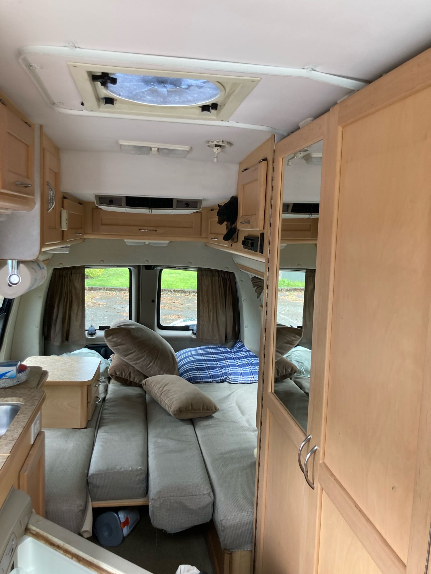 Inside an rv rental: comfortable bed cushions, storage cabinets, rear windows, and a roof vent for travel.. Pleasure Way Lexor 2005
