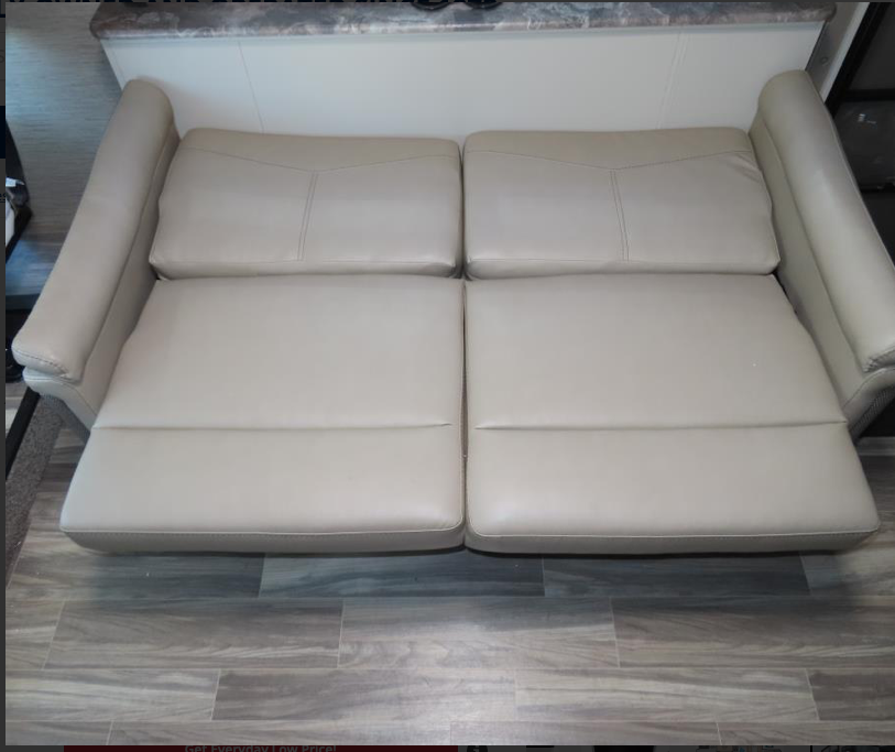 This RV rental features a comfortable, light-colored reclining sofa with two footrests, perfect for interior living.. Thor Motor Coach ACE 2022