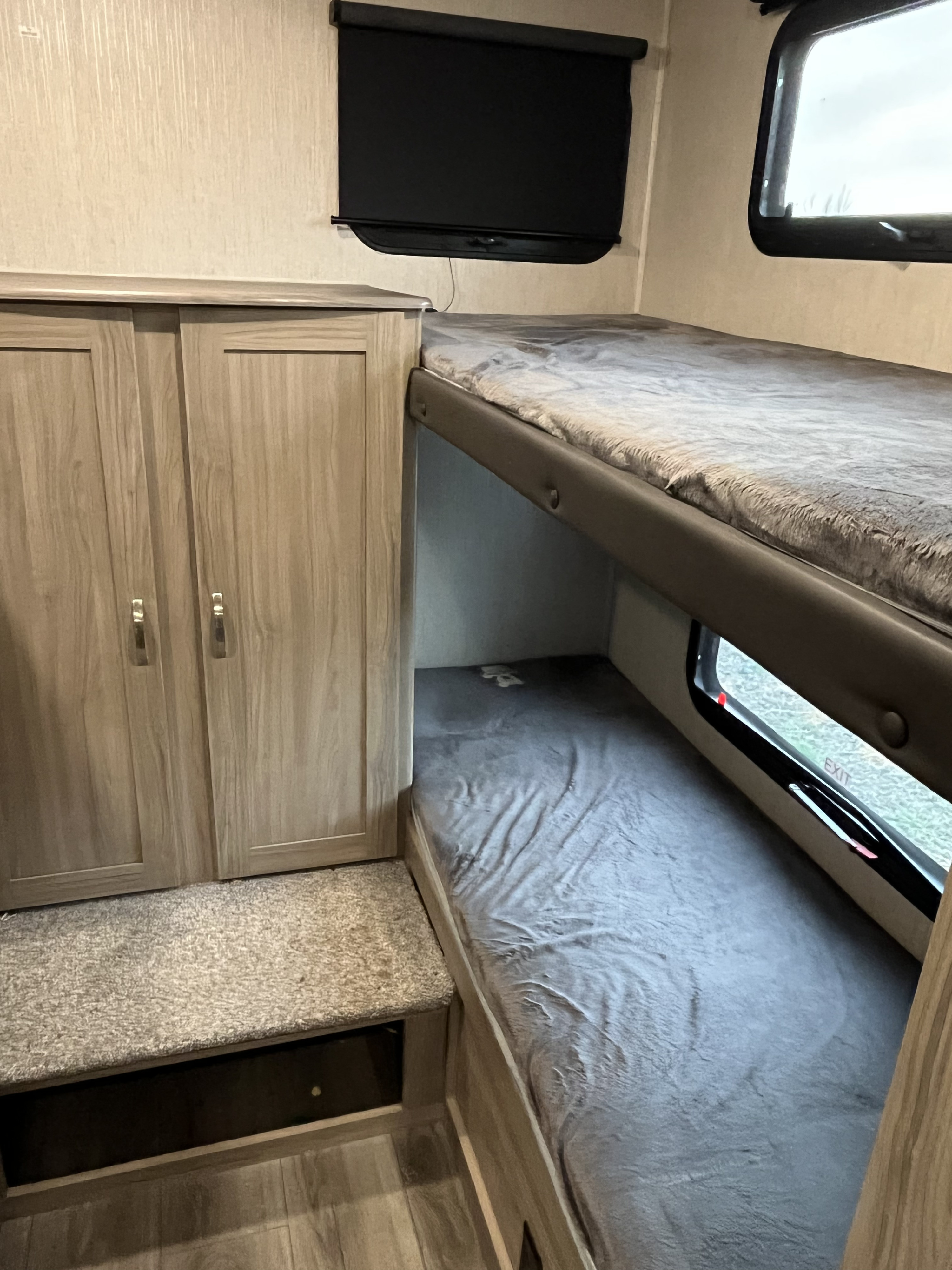 RV rental interior with bunk beds, wardrobe, and window. Comfortable and practical sleeping arrangements for your trip.. Coachmen Freedom 2021