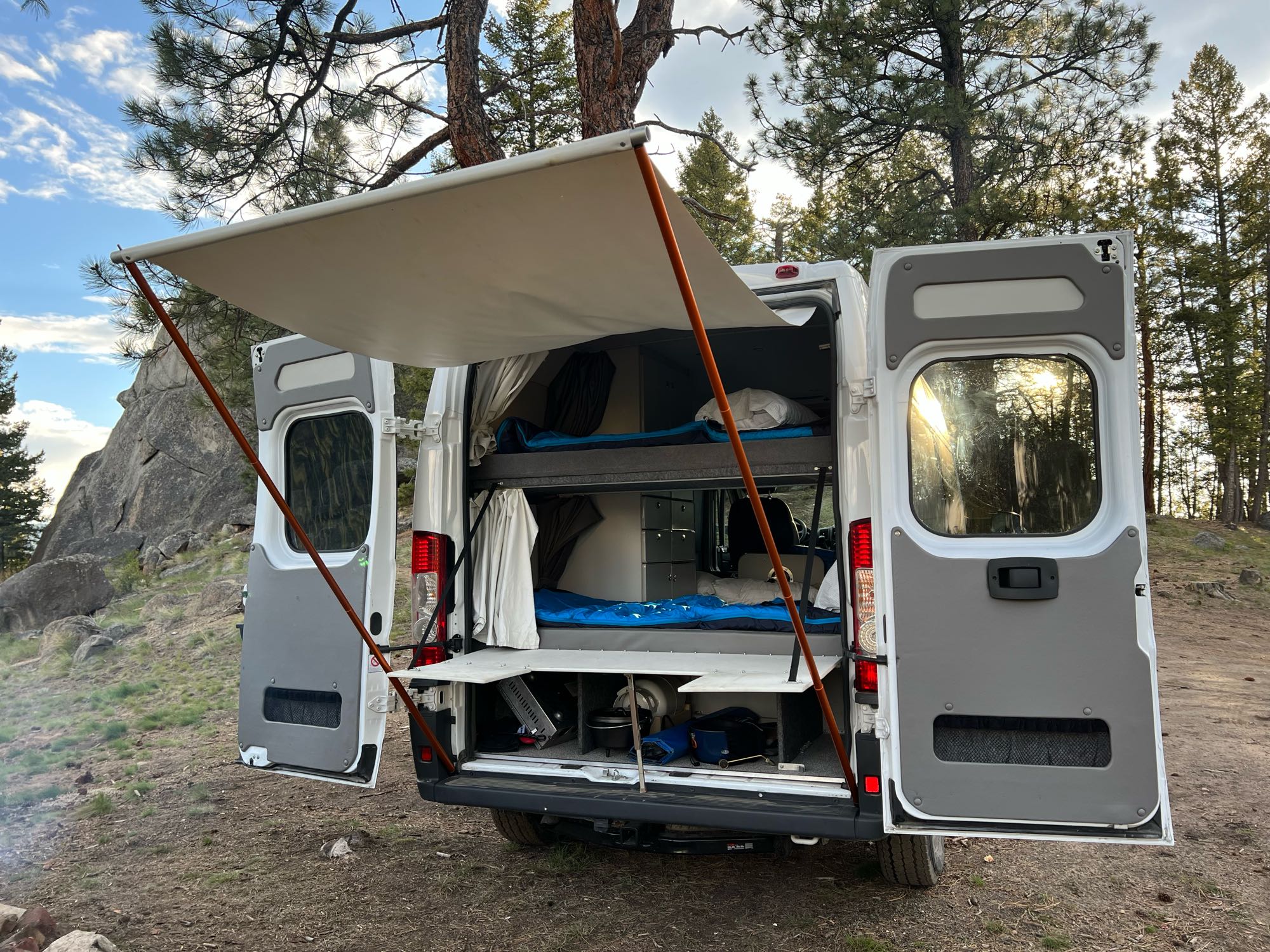 This rv rental camper van offers adventure: bunk beds, extended awning, and rear access to outdoor cooking gear for camping.. Sportsmobile Ram Promaster 2500 2019