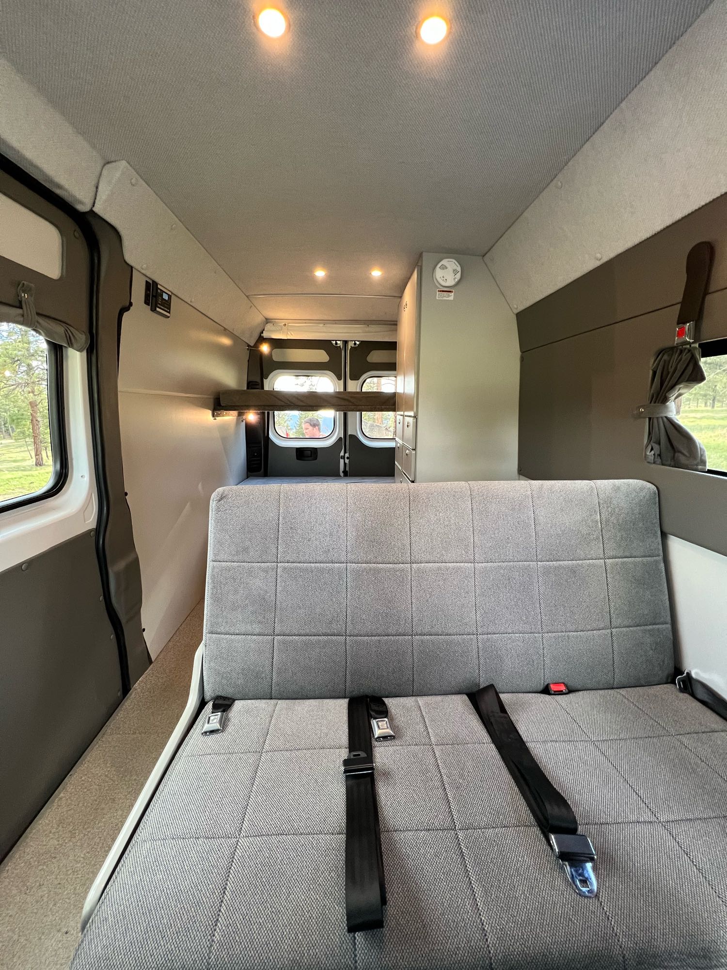 Explore this RV rental's spacious interior: gray bench seat, bunk beds, and bright ceiling lights.. Sportsmobile Ram Promaster 2500 2019