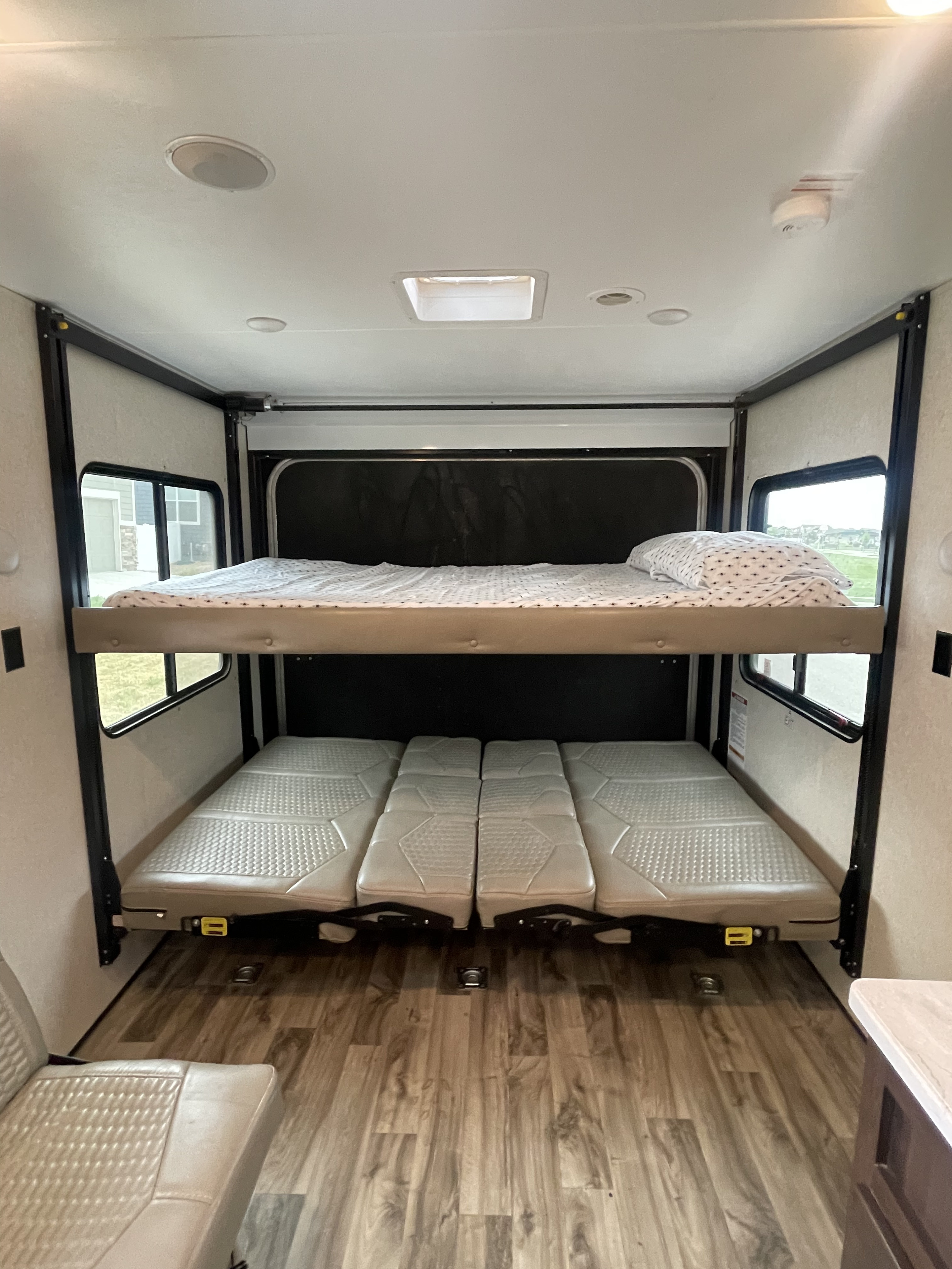Inside an RV rental: versatile garage area with two bunk beds (top one made up) and convertible seating below.. Jayco Octane 272 SL 2018