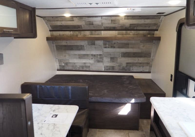 RV rental interior: A cozy dinette converts to a bed, featuring a plank wall, light counters, and dark seating.. Coleman Coleman Lantern 2022