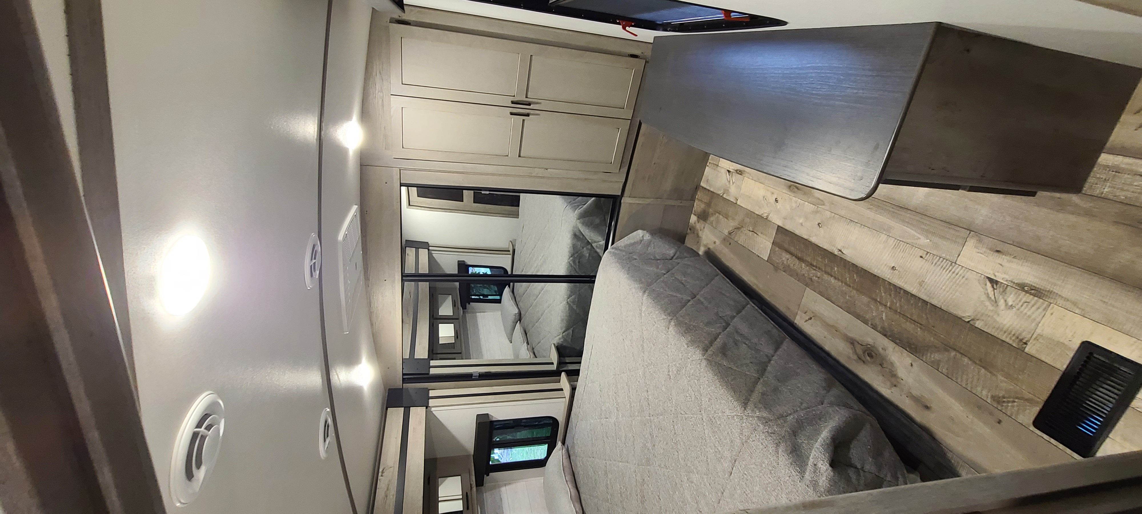 Modern rv rental bedroom with a cozy bed, wardrobe, and desk. Features wood-look flooring and bright lighting for your trip.. Keystone RV Outback 2021
