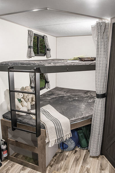 Cozy RV rental interior: bunk beds with ladder, windows, and storage, creating a practical family sleeping area.. Venture Stratus VBH261 2022