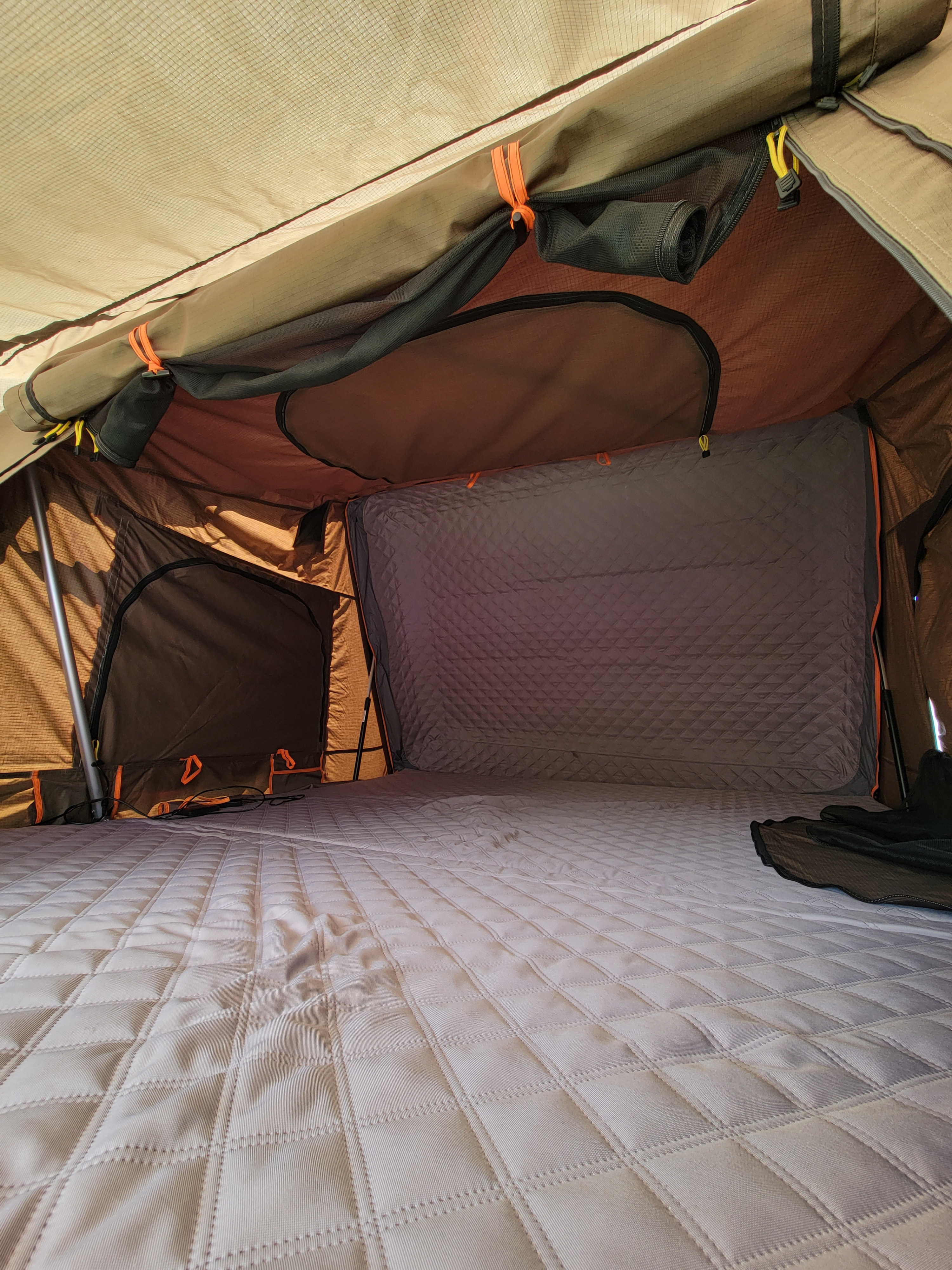 Inside an RV rental's rooftop tent, showcasing a spacious, comfortable quilted mattress and sturdy fabric interior.. Toyota Tundra 2011