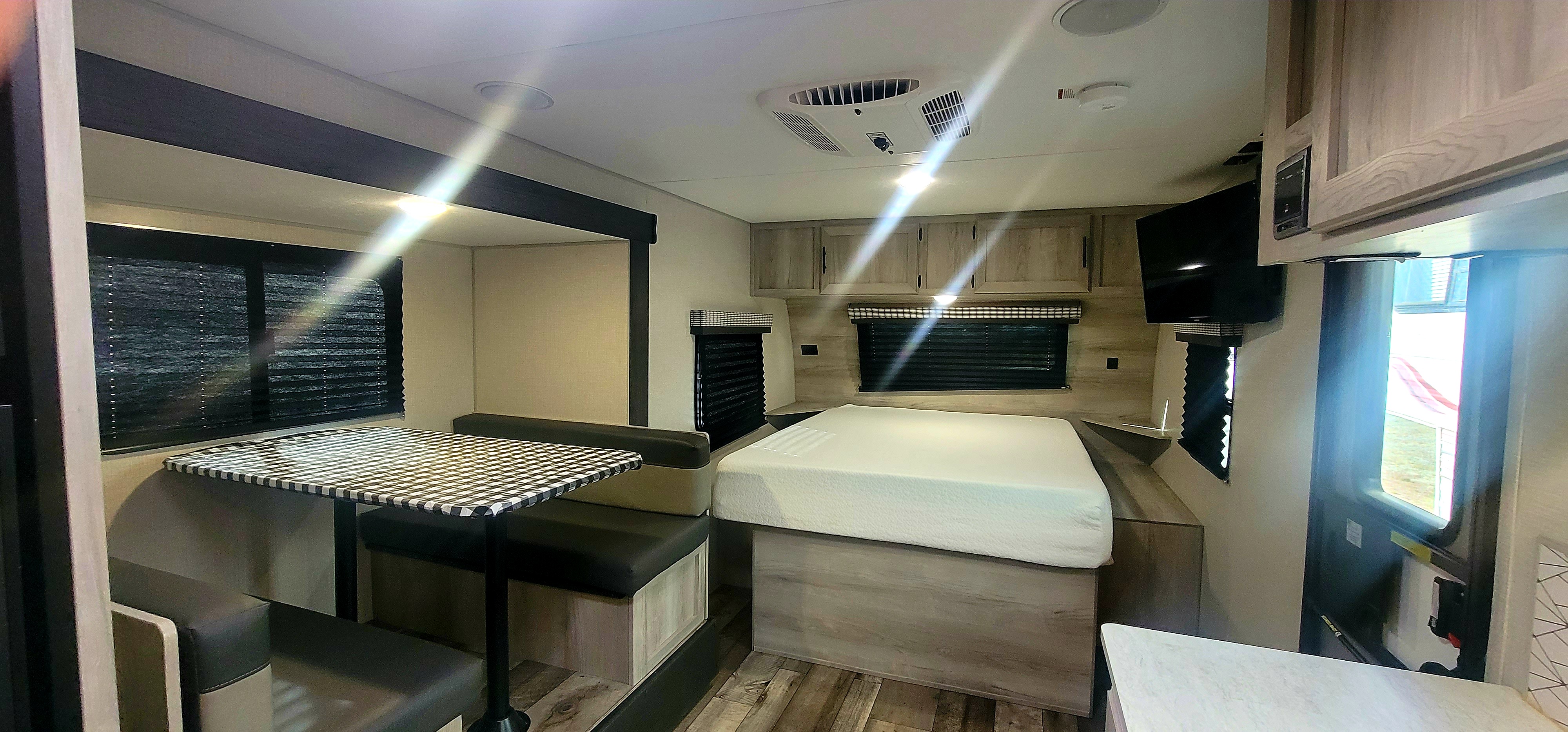 Spacious RV rental interior with a cozy bed, dining area, and full amenities for comfortable travel adventures.. Escape Trailer Industries 21 Foot Escape 2020