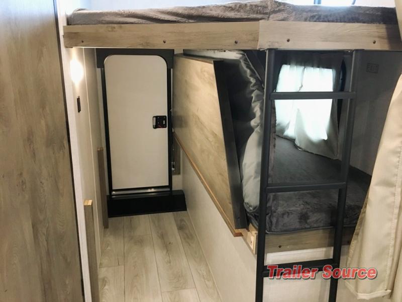 Cozy RV rental interior: bunk beds with ladder, privacy curtains, and hallway with door for compact living.. Forest River Surveyor Legend 2022