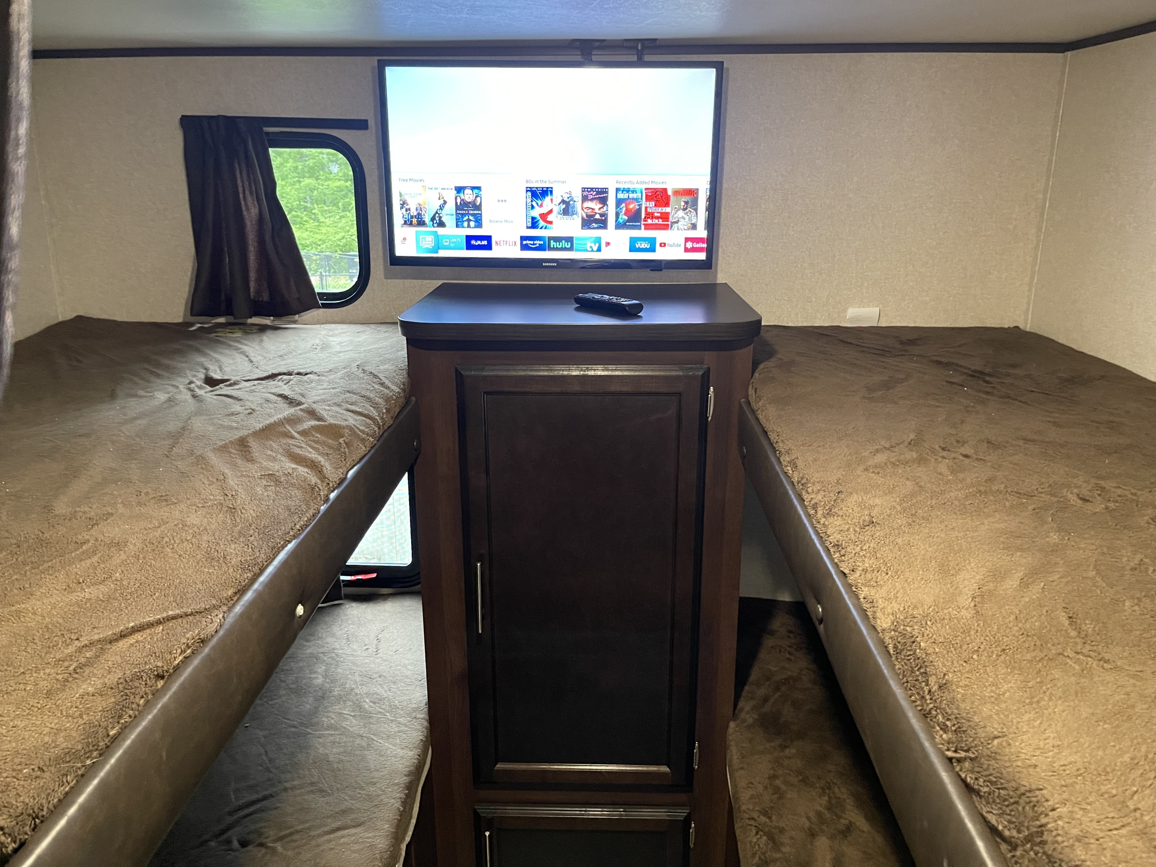 Cozy RV rental interior with dual bunk beds and a smart TV setup for entertainment, perfect for family trips.. Jayco Flight 2019