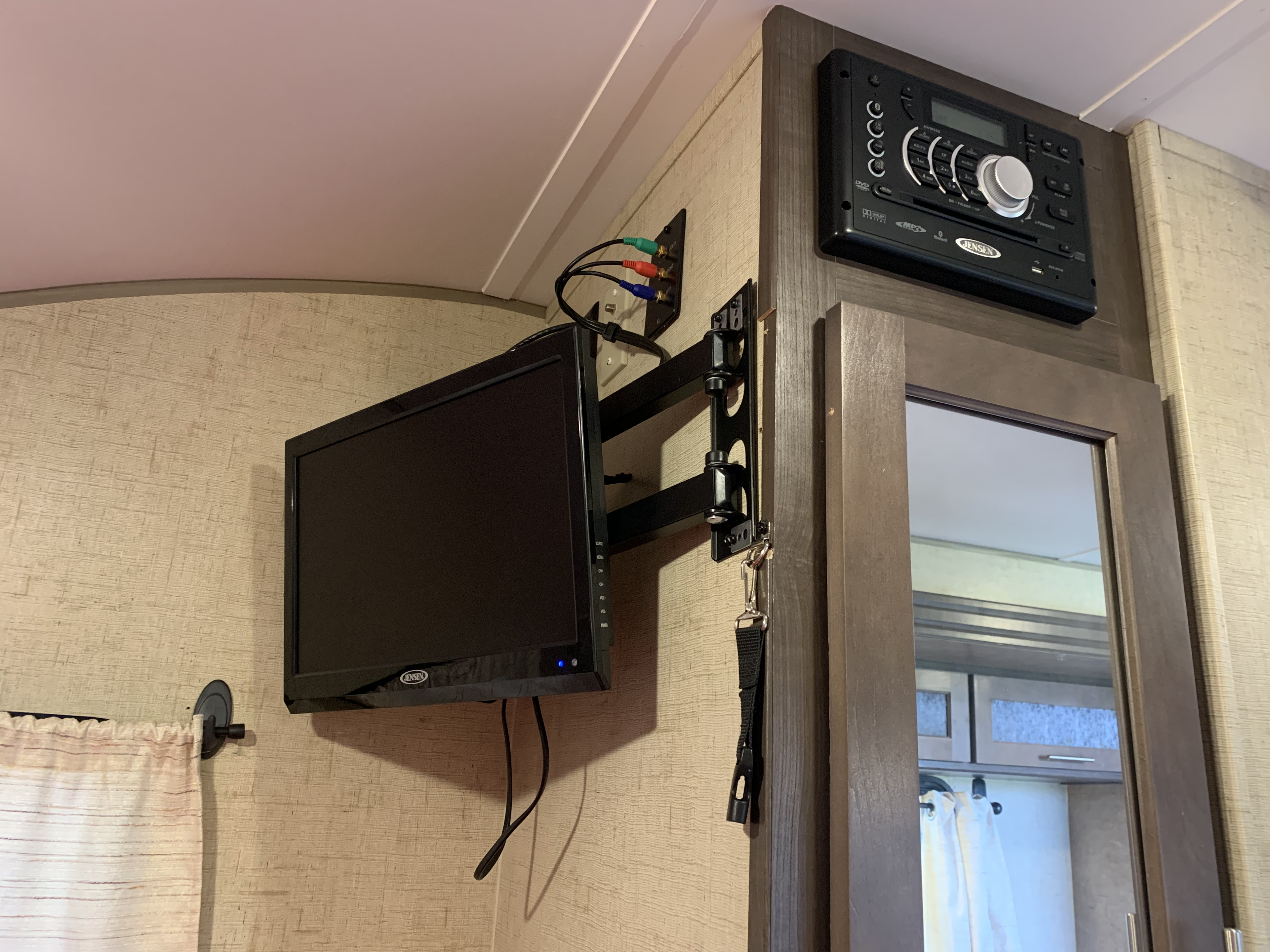RV rental space with a wall-mounted TV on an articulating arm and a Jensen stereo. Includes mirror and curtain for compact living.. Forest River R.POD TOWABLE 2016