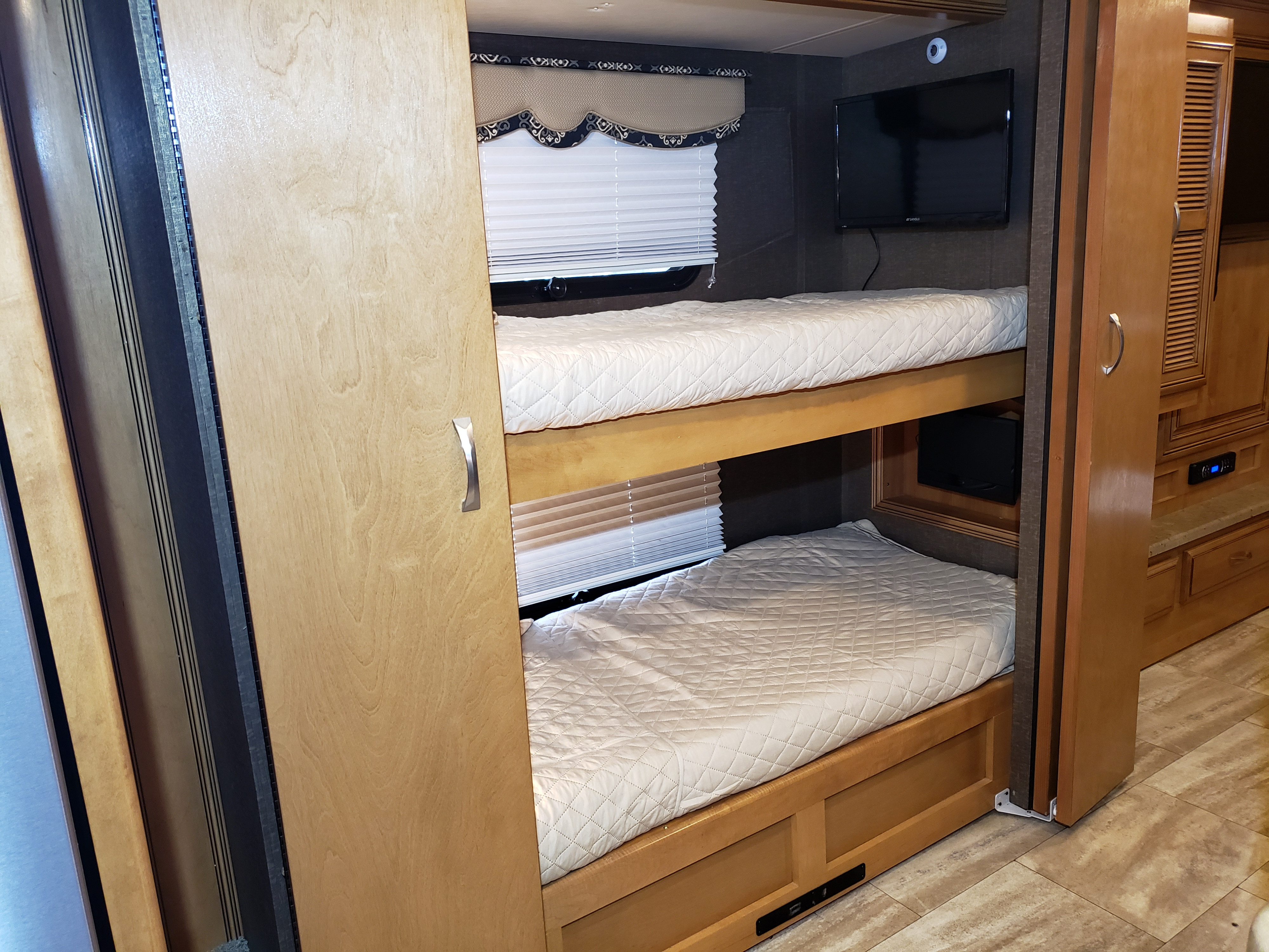 RV rental bunk beds: This modern motorhome offers cozy sleeping areas with individual TVs and window blinds.. Thor Challenger 2016
