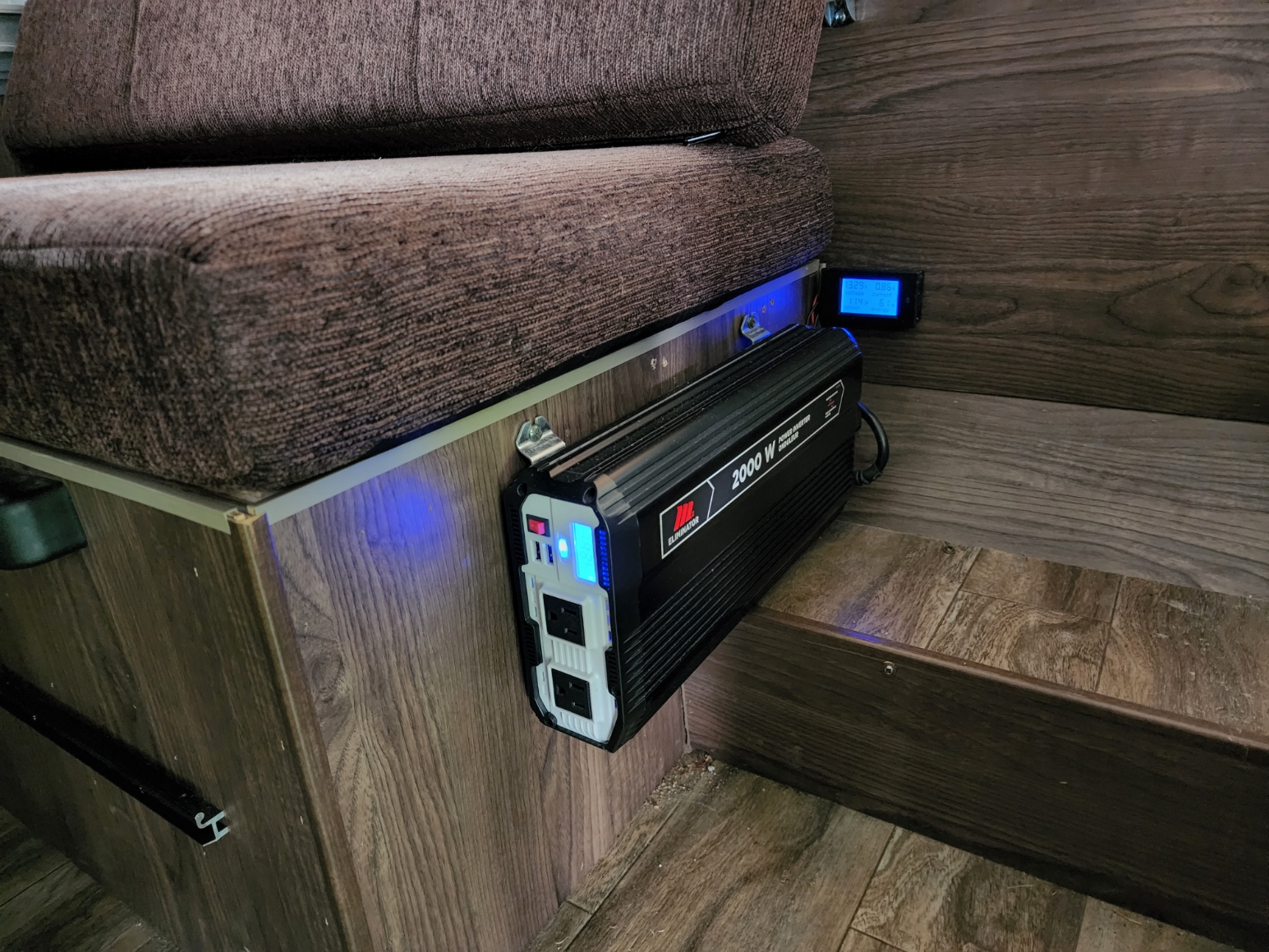 RV rental: A 2000W power inverter with bright blue indicator lights and a digital display, mounted beneath a brown cushion.. Flagstaff mac 206 pop up 2018