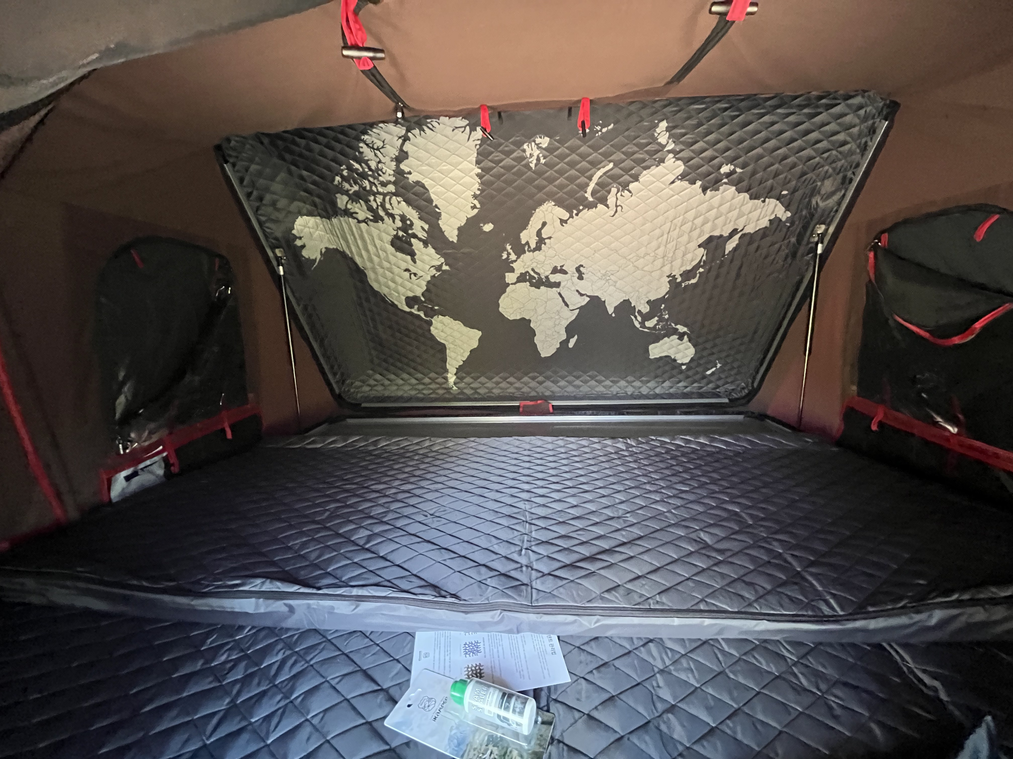 Spacious RV rental interior featuring a cozy quilted bed and a cool world map ceiling, perfect for travel adventures.. Other tacoma overland 2013
