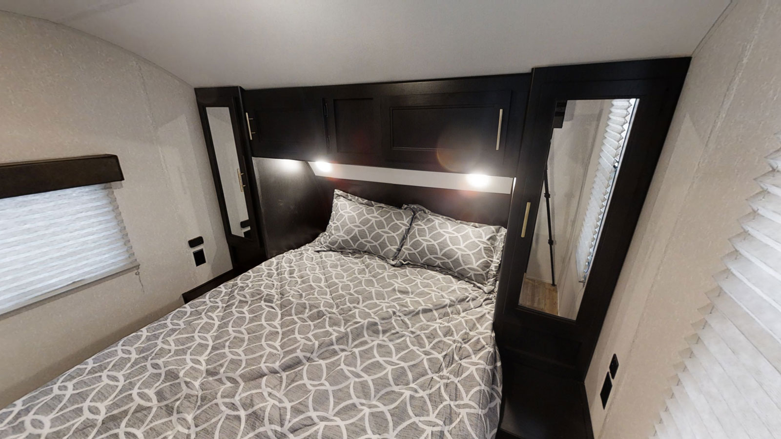 RV rental: Relax in this compact bedroom with patterned bedding, overhead lights, and integrated storage. Perfect for road trips.. Forest River Cherokee Grey Wolf 2022