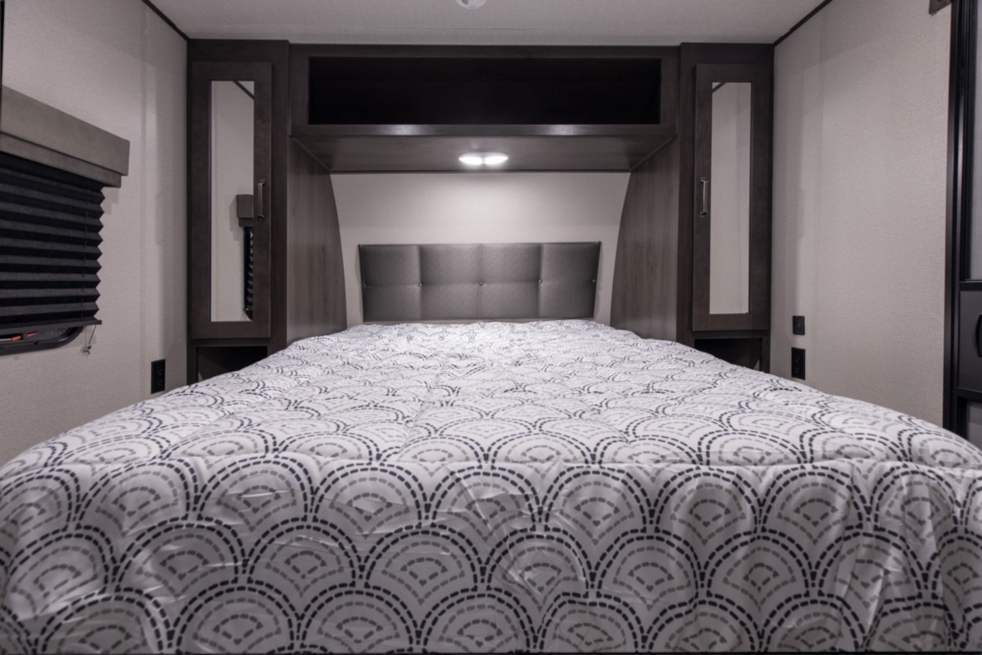 Cozy RV rental bedroom with a comfy bed, headboard, and overhead storage, perfect for mobile living.. Grand Design Transcend Xplor 2021