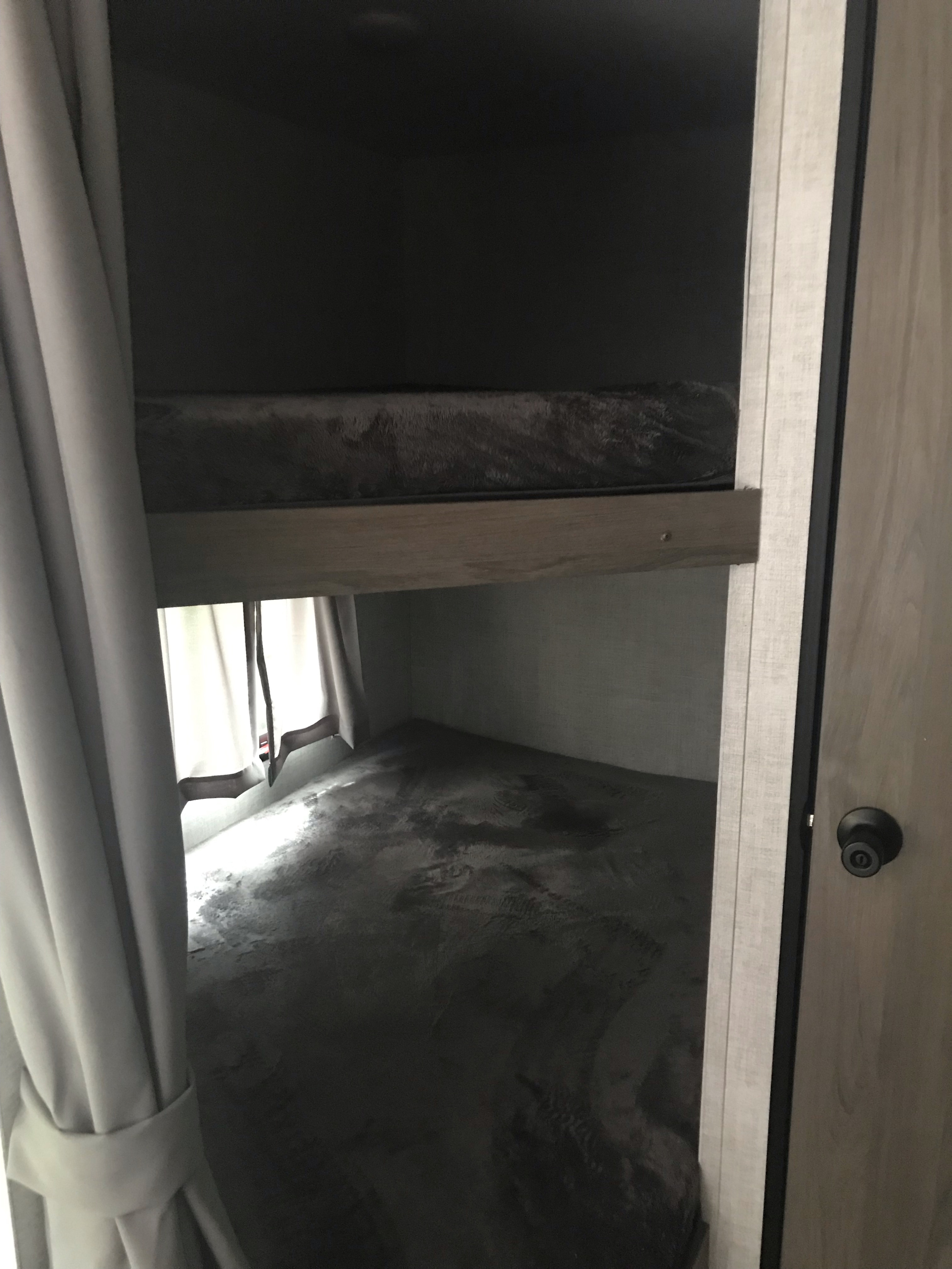 Cozy RV rental bunk beds, ready for a comfortable night's sleep in a compact sleeping area.. 1NL1G2725N6008015 ENLIGHTEN 2022