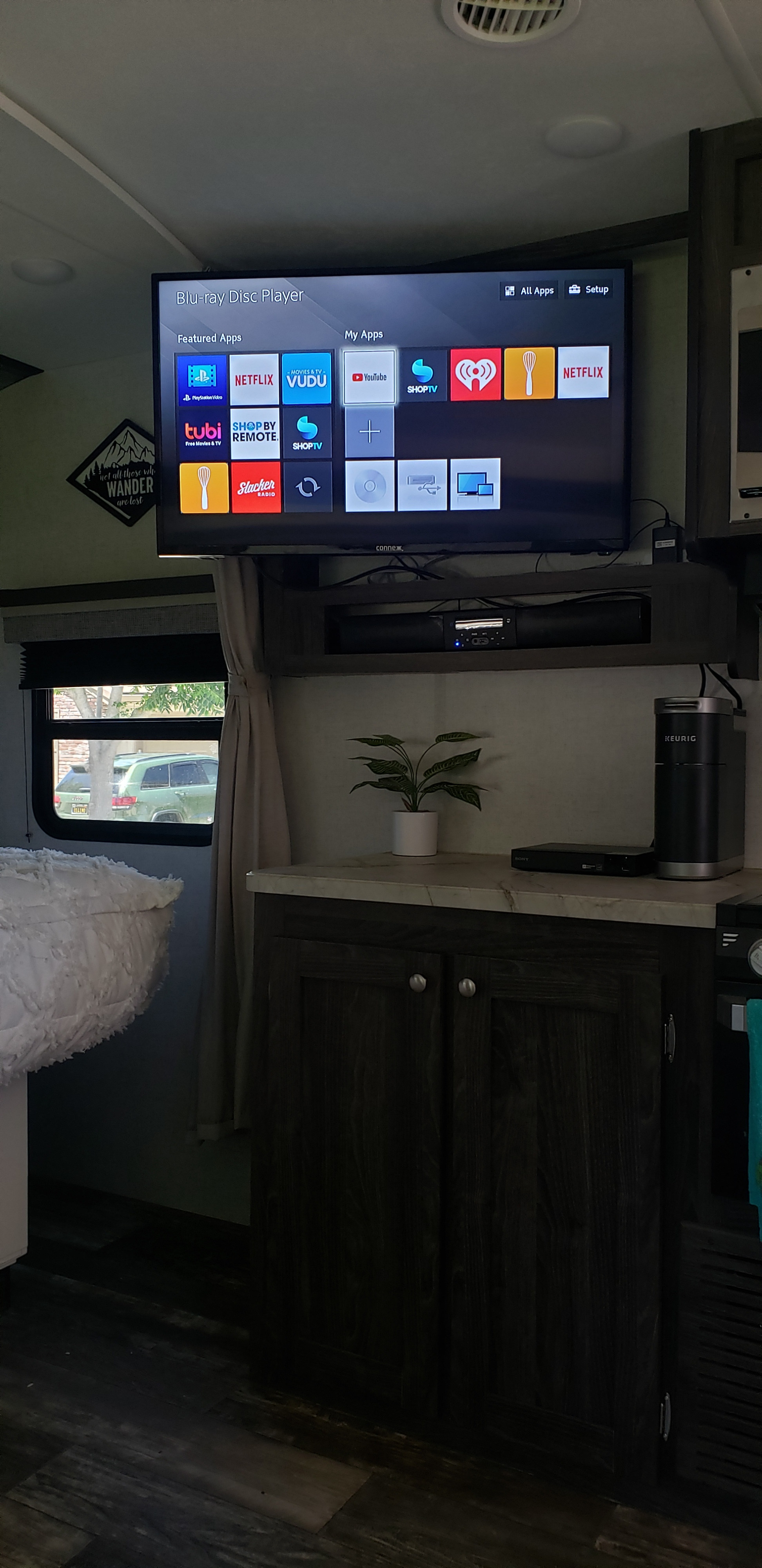 Inside an RV rental: entertainment hub with TV showing streaming apps, Blu-ray player, and Keurig in a cozy space.. Starcraft Super Lite 2020