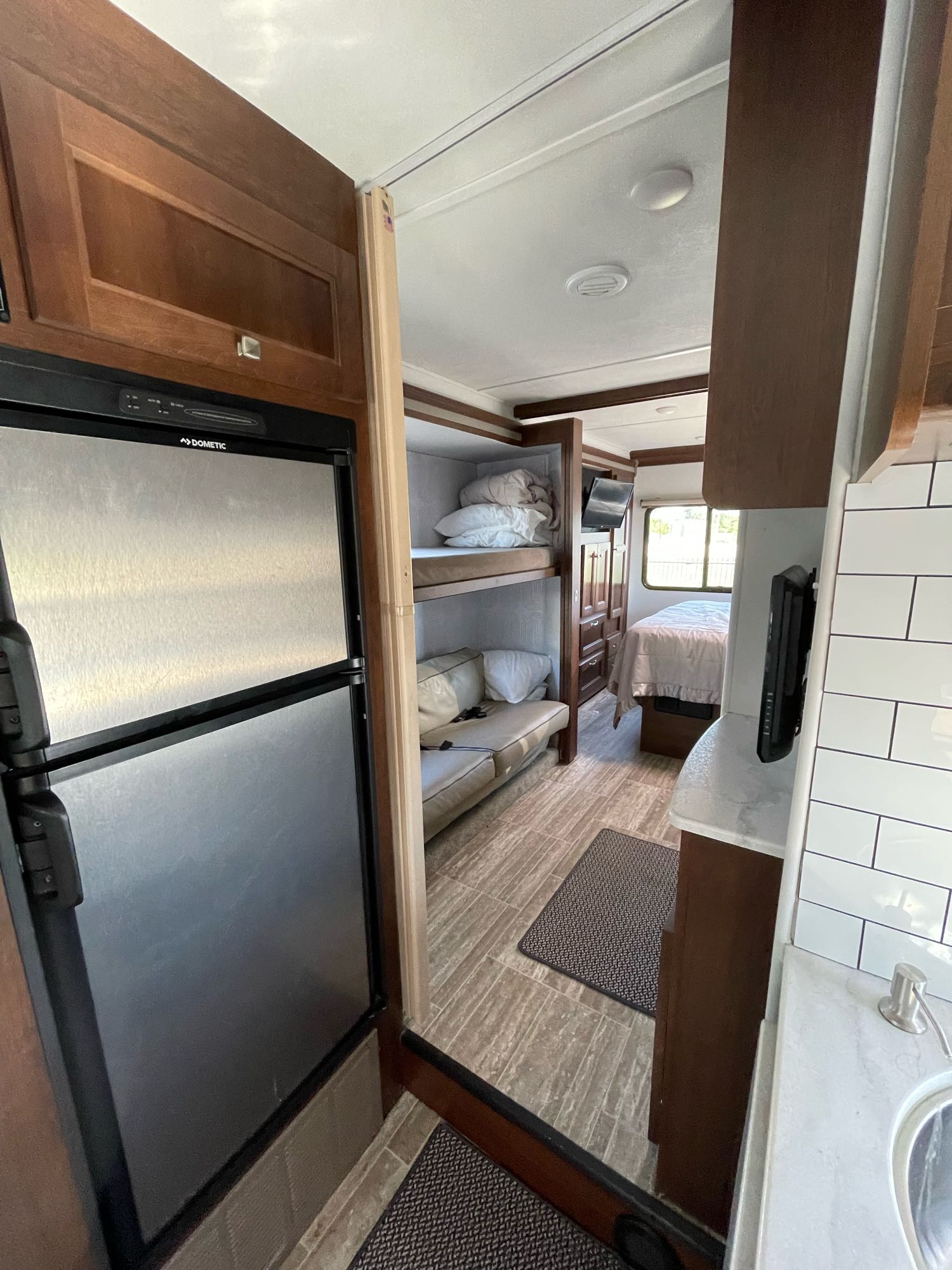 Spacious RV rental interior featuring a Dometic fridge, bunk beds, kitchen, and comfortable main bedroom.. Forest River Sunseeker LE 2019