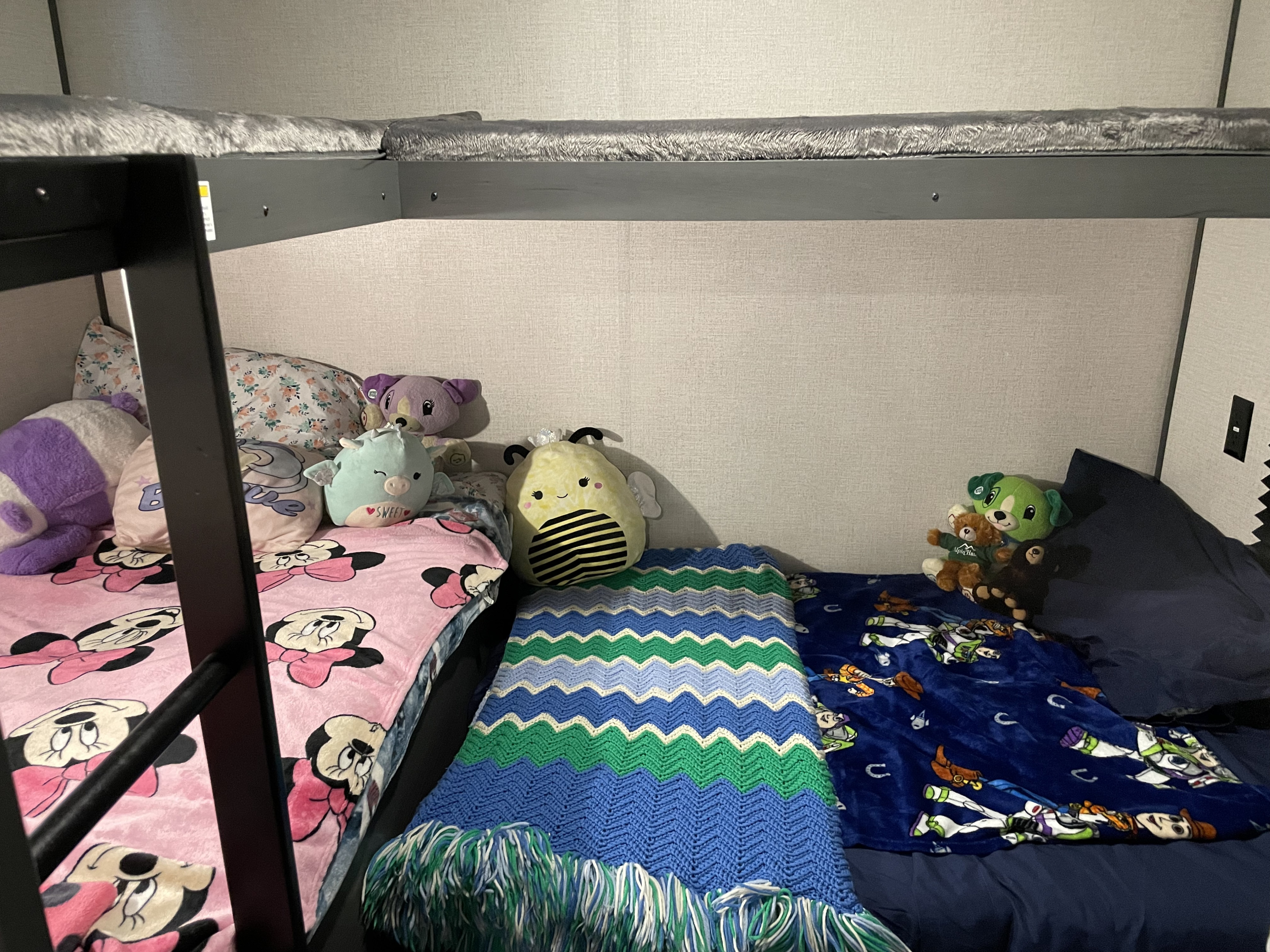 Cozy RV rental bunk beds with stuffed animals and character blankets, perfect for kids.. Dutchman Colorado 2022