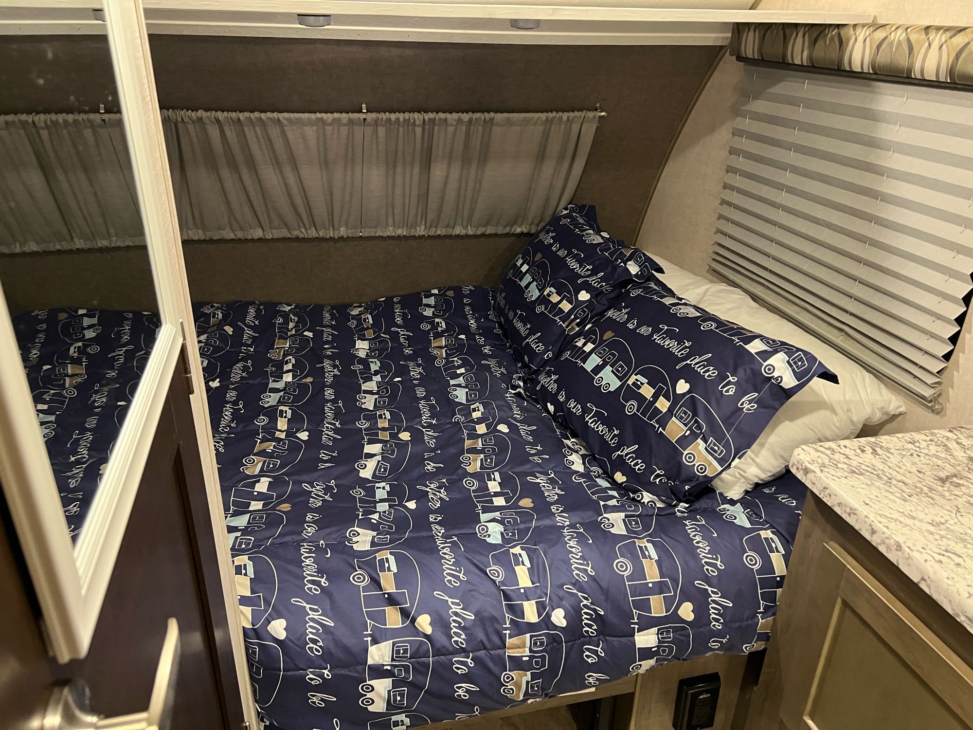 RV rental interior: Cozy bedroom with a camper-themed bed, mirrored closet, and privacy blinds.. Forest River Other 2017