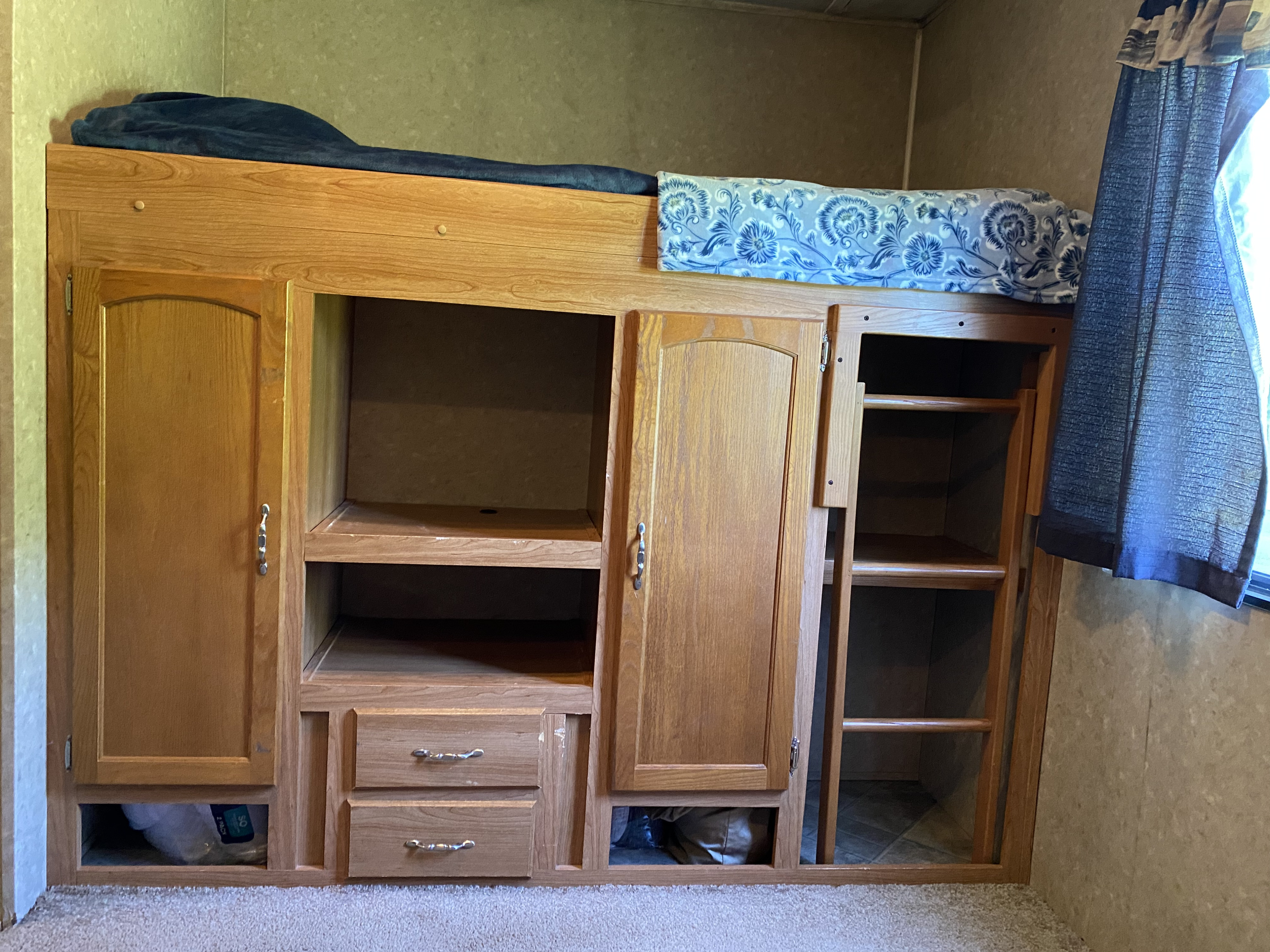 RV rental: Wooden bunk bed with built-in storage cabinets, drawers, and ladder. A cozy, organized sleeping area in a travel trailer.. Forest River Palomino Puma 2008