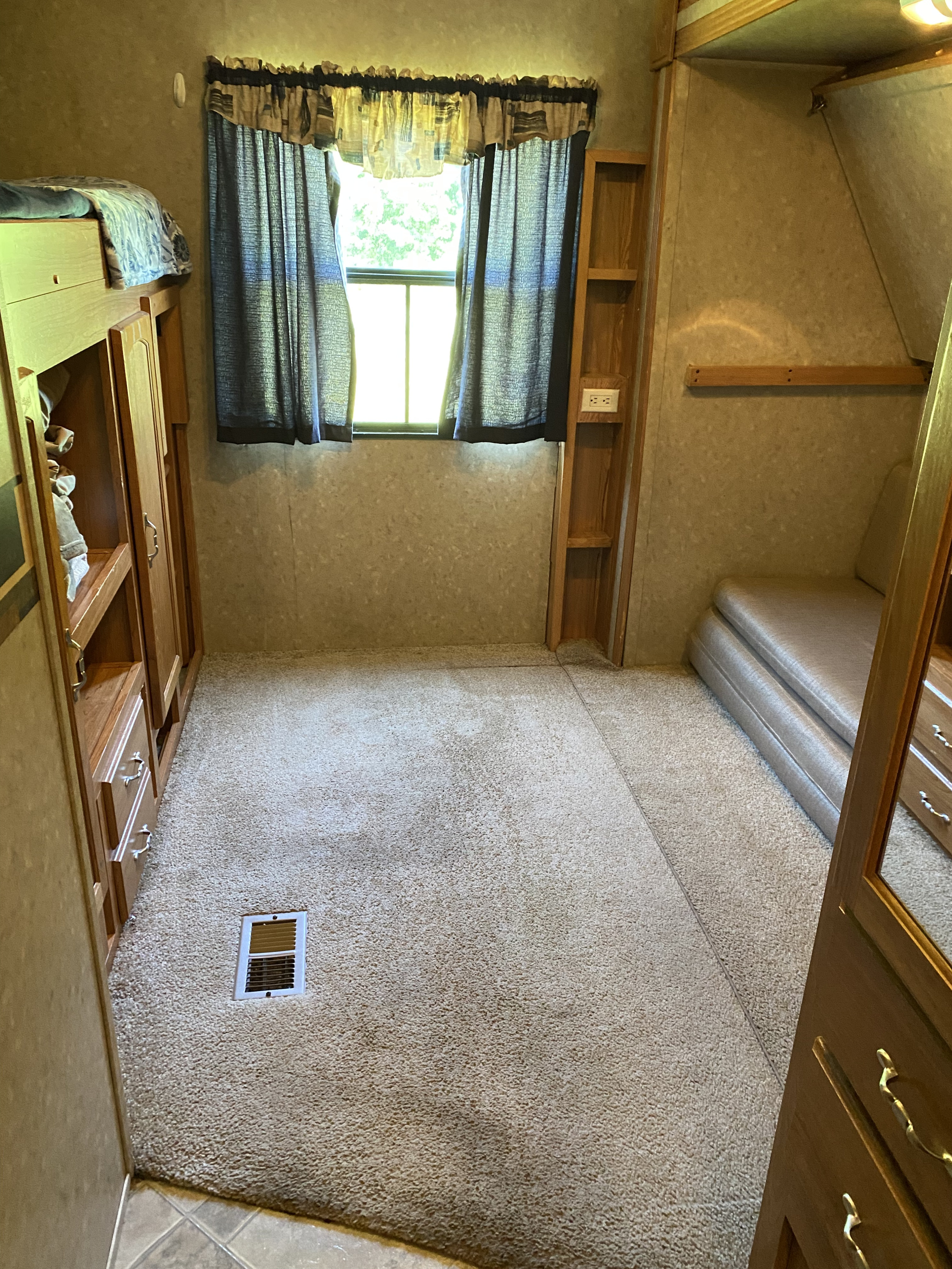 RV rental: Cozy bedroom with bunk beds, carpet, window, and wood storage. Ready for your next adventure.. Forest River Palomino Puma 2008