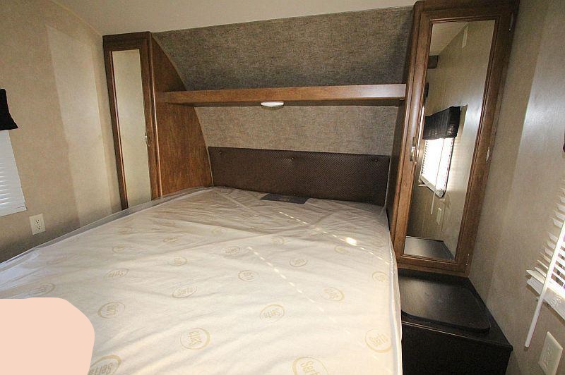 RV rental bedroom showcasing a bed with overhead shelf, mirrored wardrobe, and storage. Ready for your adventure.. Forest River Salem 2017