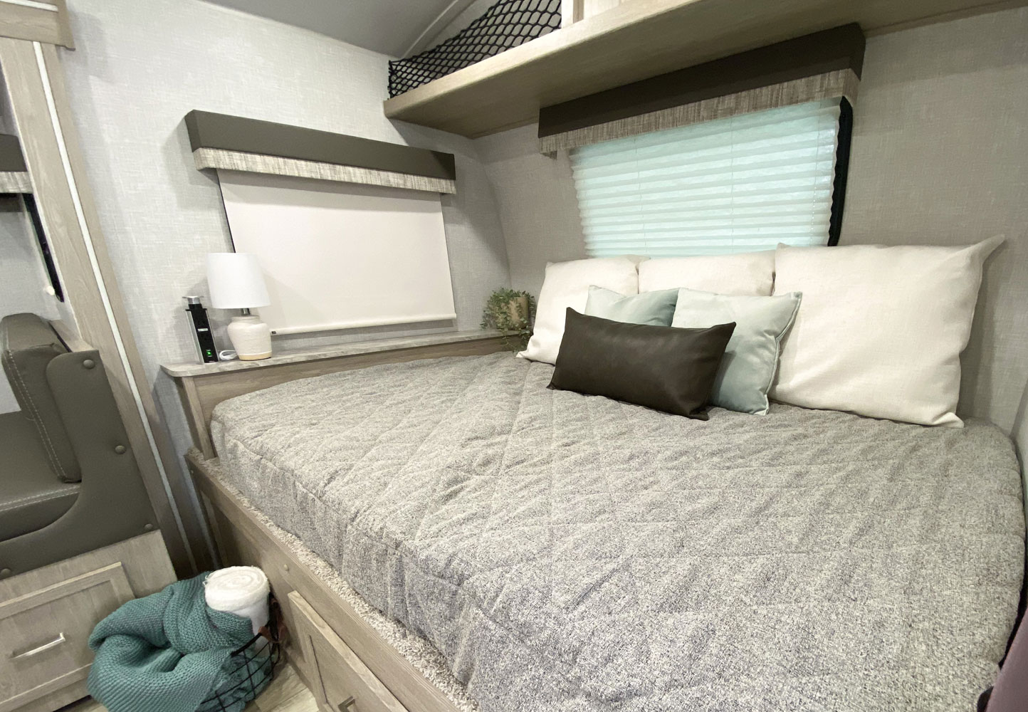 Cozy RV rental interior features a comfortable bed, multiple pillows, window with blinds, and practical storage solutions.. Forest River Flagstaff E-Pro 20BHS 2022