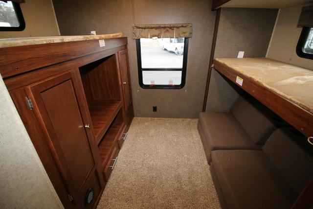 RV rental bunkhouse area: Left side has bunk over storage, center a window, right side bunk over sofa bed. Carpeted floor.. Heartland M-3385 2017