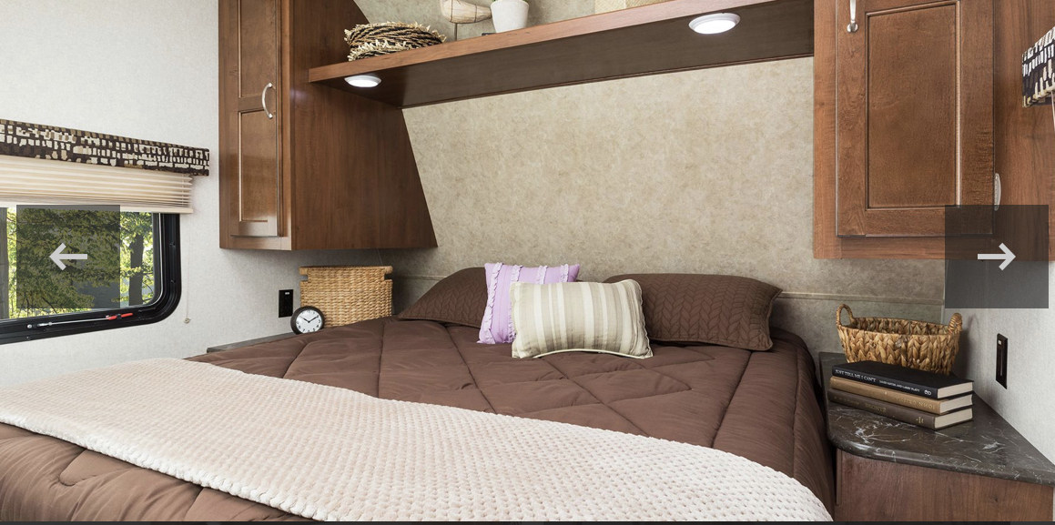 Comfortable RV rental bedroom with dark wood cabinets, a cozy bed, and window views. Ideal for your travel adventures.. Jayco Jay Flight SLX Baja Edition 2017