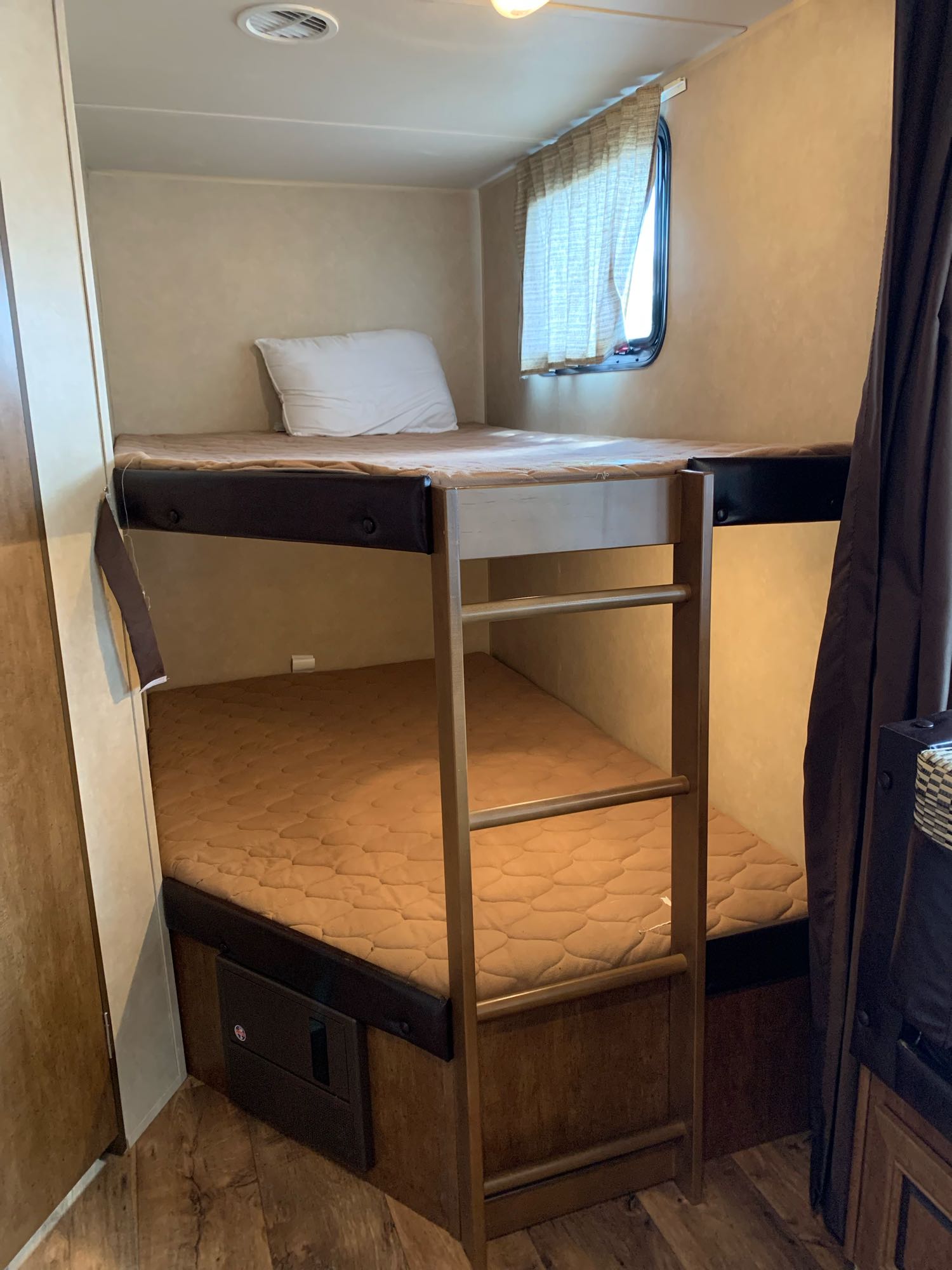 RV rental: Bunk beds with ladder, window, and mattresses, offering a compact sleeping area.. Forest River Wildwood X-Lite 2016