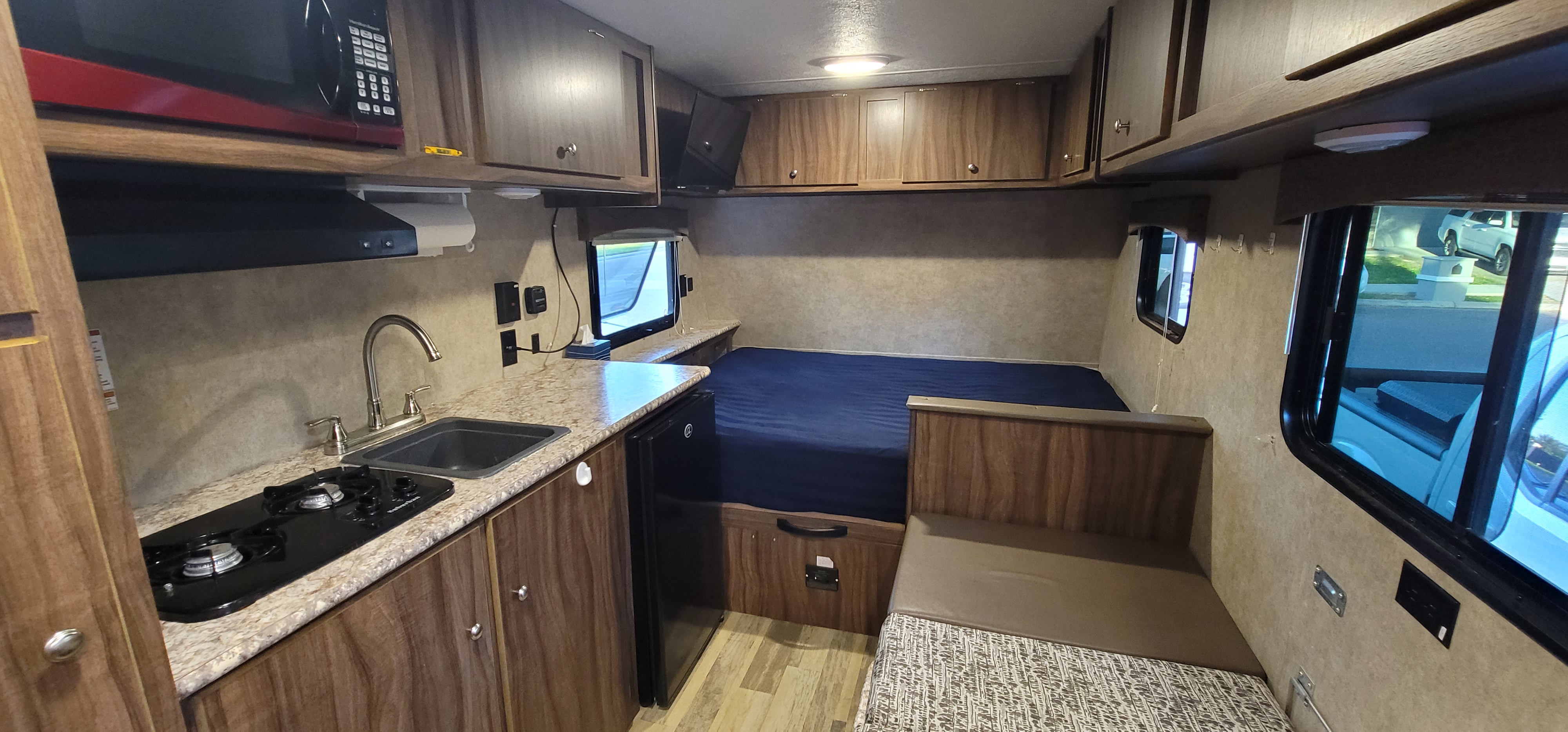 Cozy rv rental interior featuring a compact kitchen, sleeping area, and dinette seating for comfortable travel.. Forest River Viking 2018