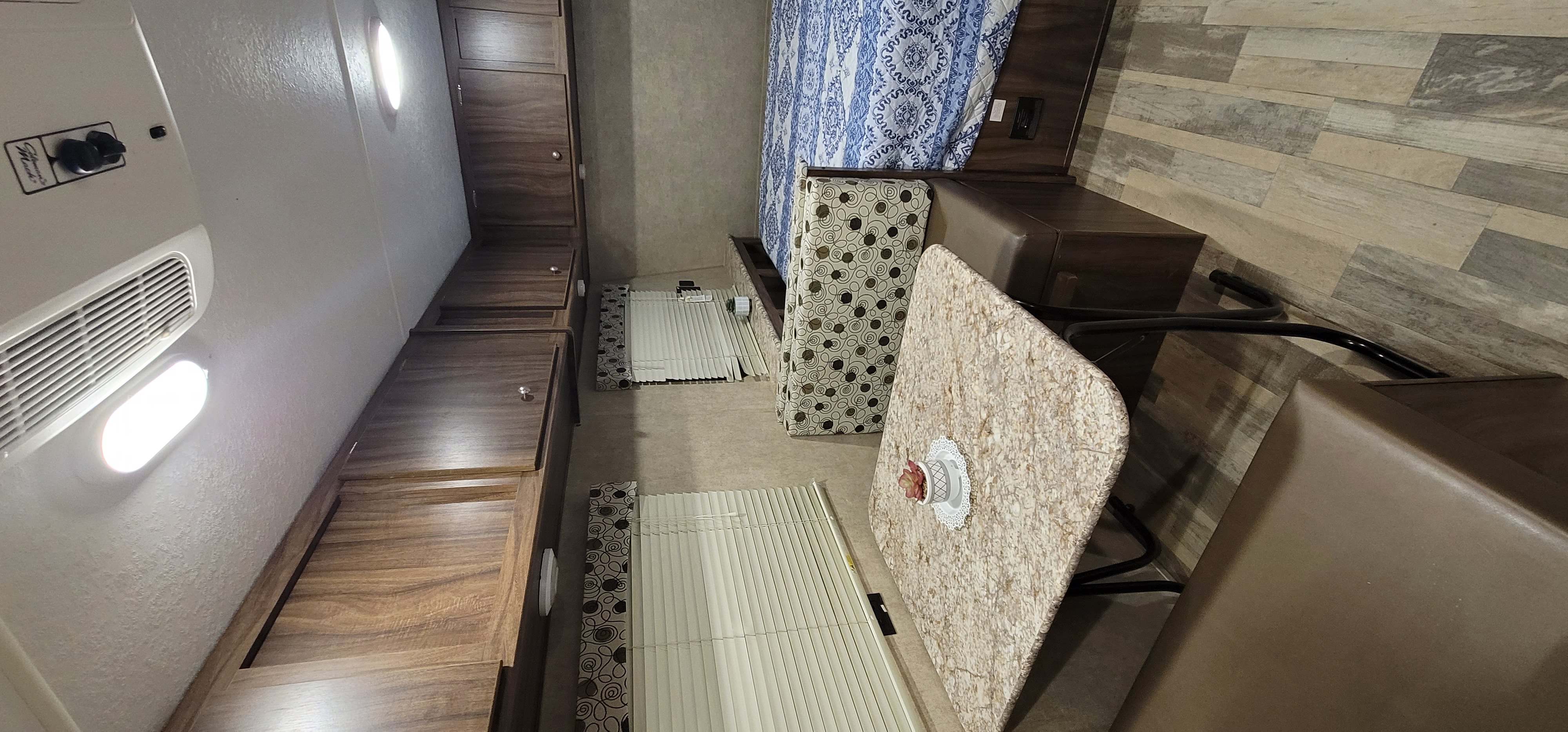 Cozy RV rental interior: compact bedroom area, dinette table, and built-in storage solutions. Perfect for travel.. Clipper Cadet 2019