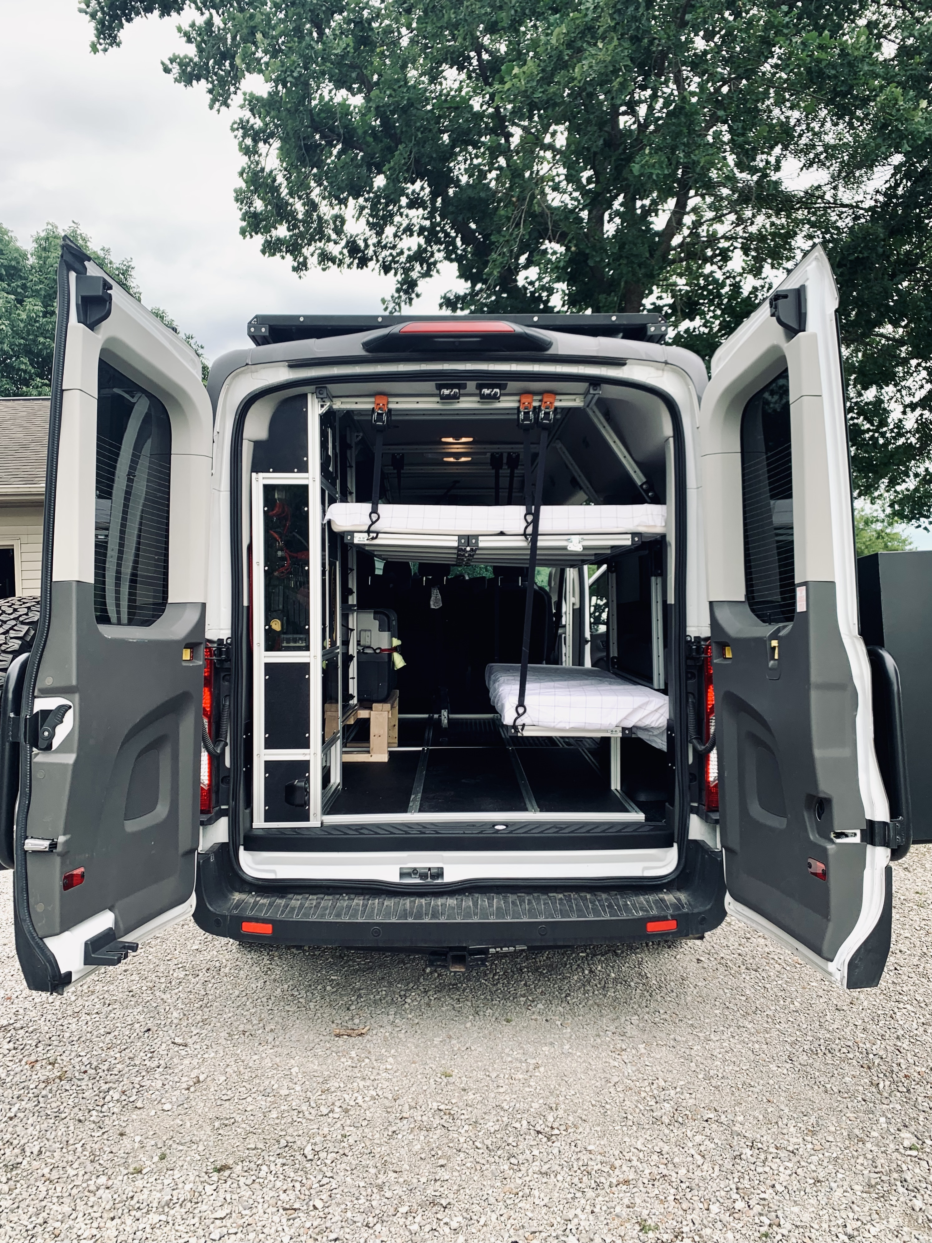 Customized camper van with open rear doors, revealing a versatile interior featuring a suspended bed, storage, and essentials for RV rental.. Vandoit Vandoit Class B 2020