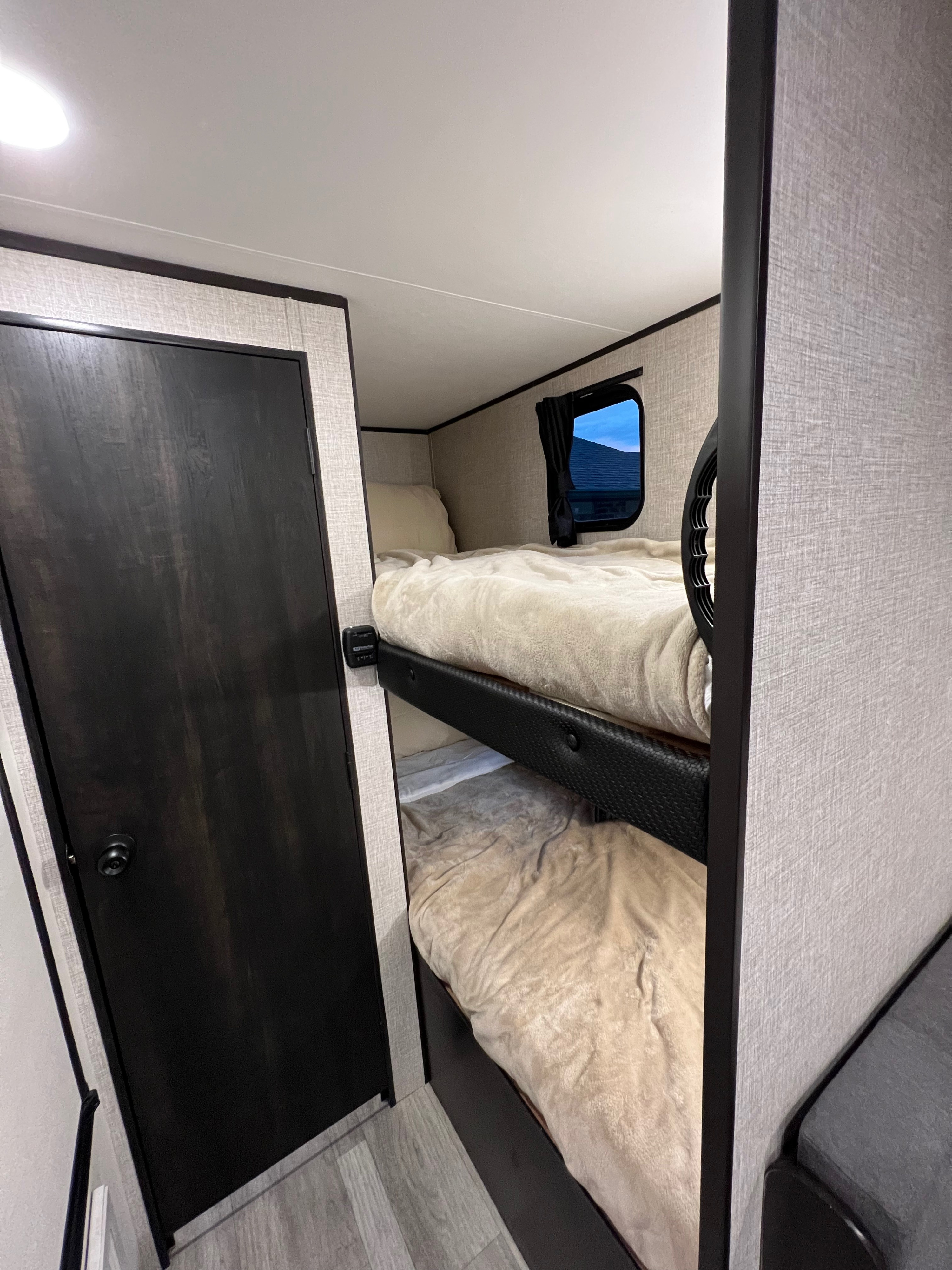 Cozy bunk beds in this RV rental, featuring textured walls and a window. Ideal for comfortable family camping.. Jayco Other 2022