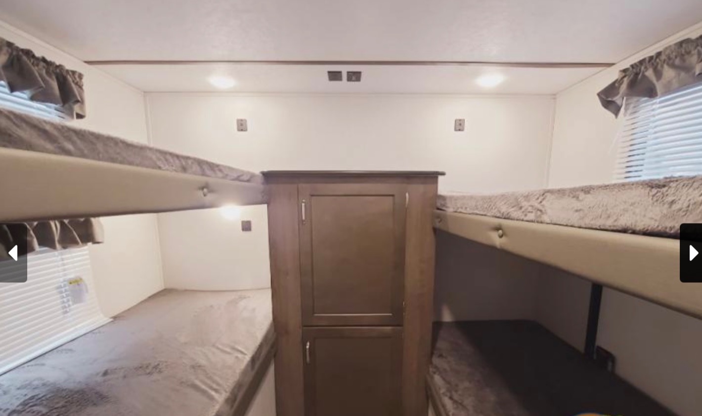 Explore this RV rental's bunkhouse: four sleeping berths with mattresses, a central cabinet, and windows.. Keystone RV Passport SL 2021