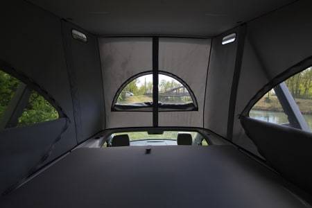 Cozy pop-top car camper interior, offering scenic views from the bed. Ideal for your RV rental adventure.. Volkswagen California Coast T6.1 DSG7 2022