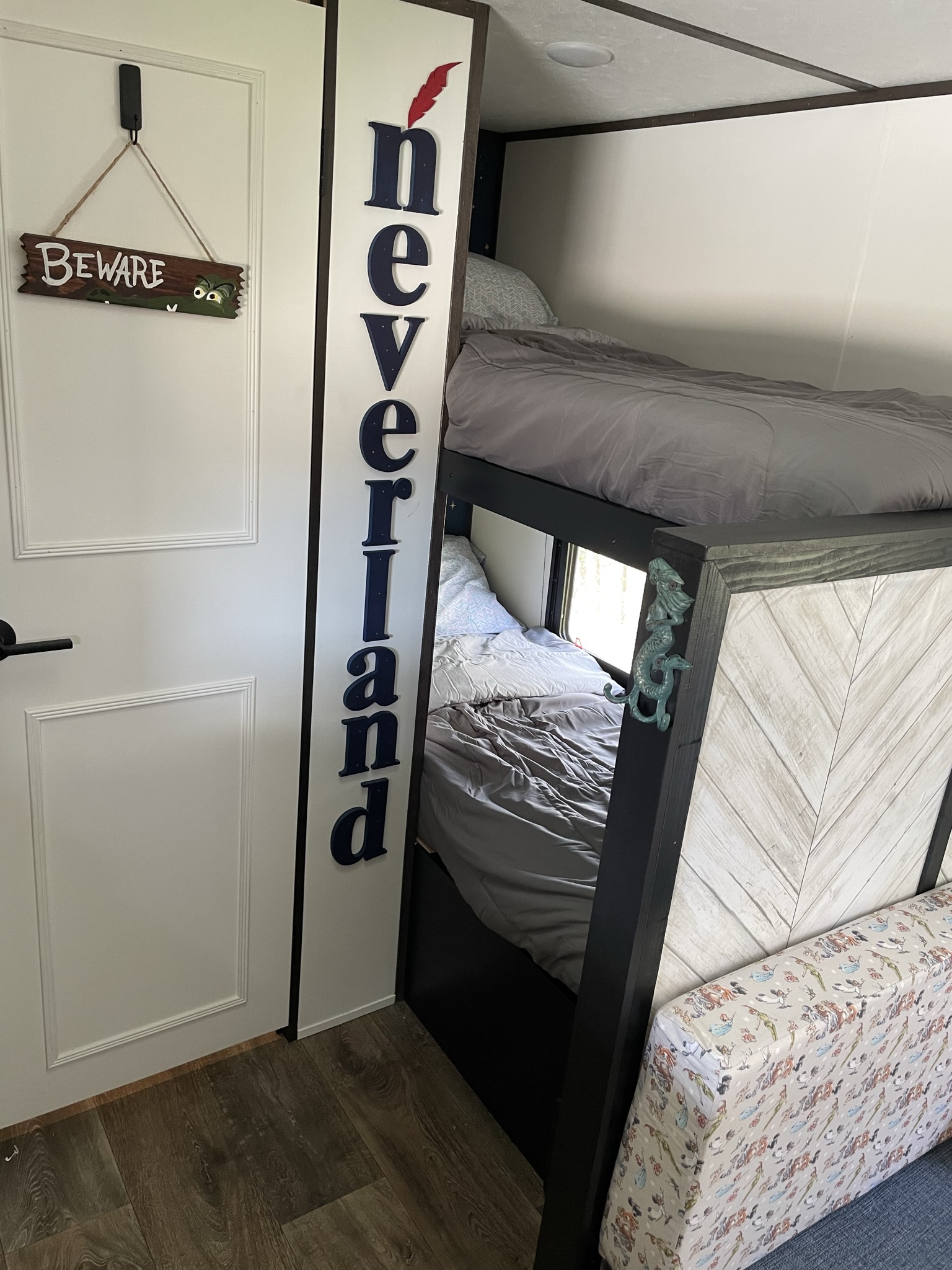 Neverland-themed bunk beds, with a crocodile "Beware" sign and mermaid decor, cozy up this RV rental interior.. Dutchmen Coleman Lantern LT 2021