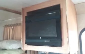 CRT TV in a ceiling-mounted wood cabinet inside an RV rental, offering onboard entertainment.. Forest River Sunseeker LE 2005