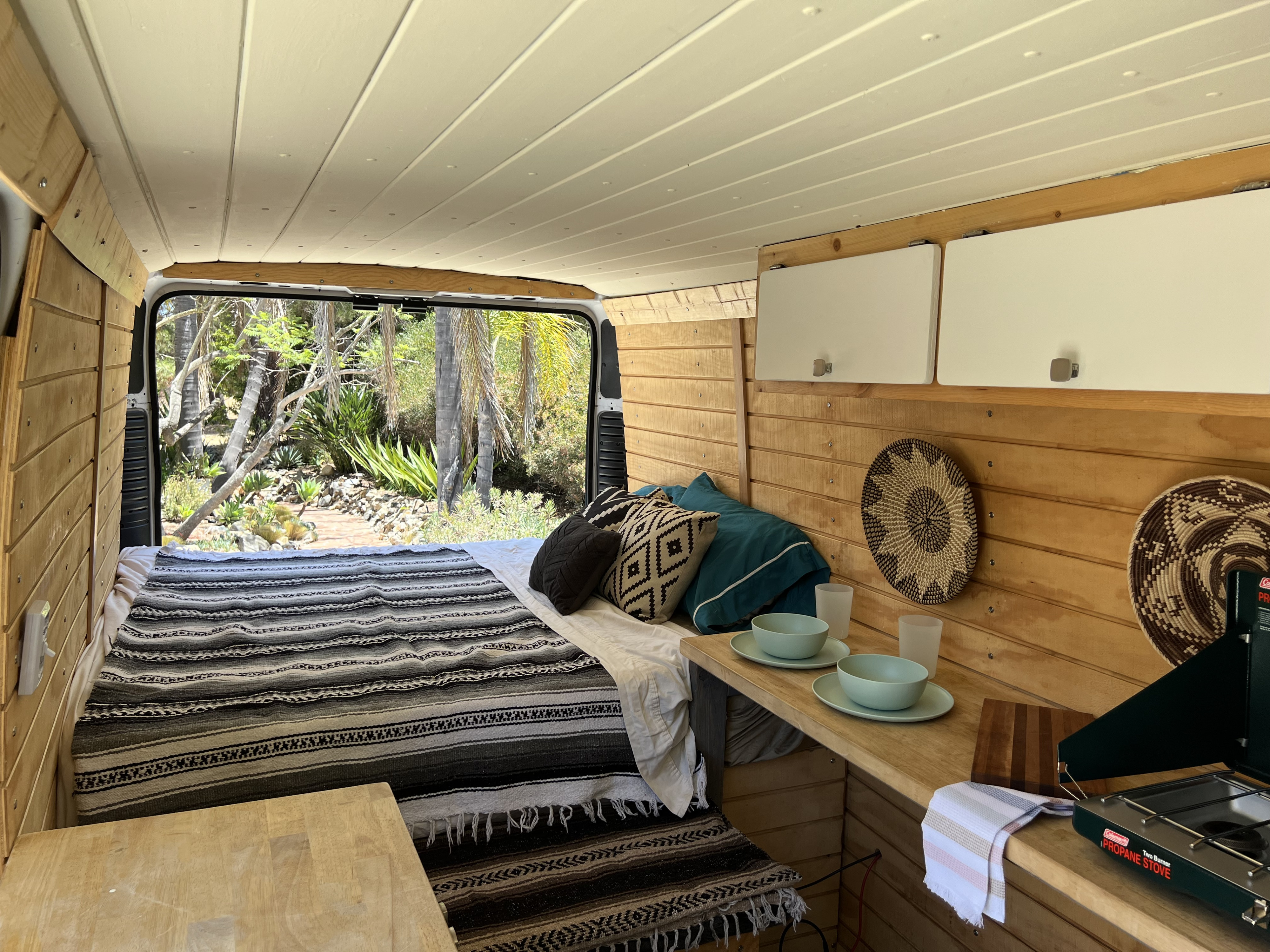 Perfect RV rental for adventure: comfy bed, kitchenette, and stunning outdoor scenery through the open back.. Dodge Ram Promaster 2500 2017