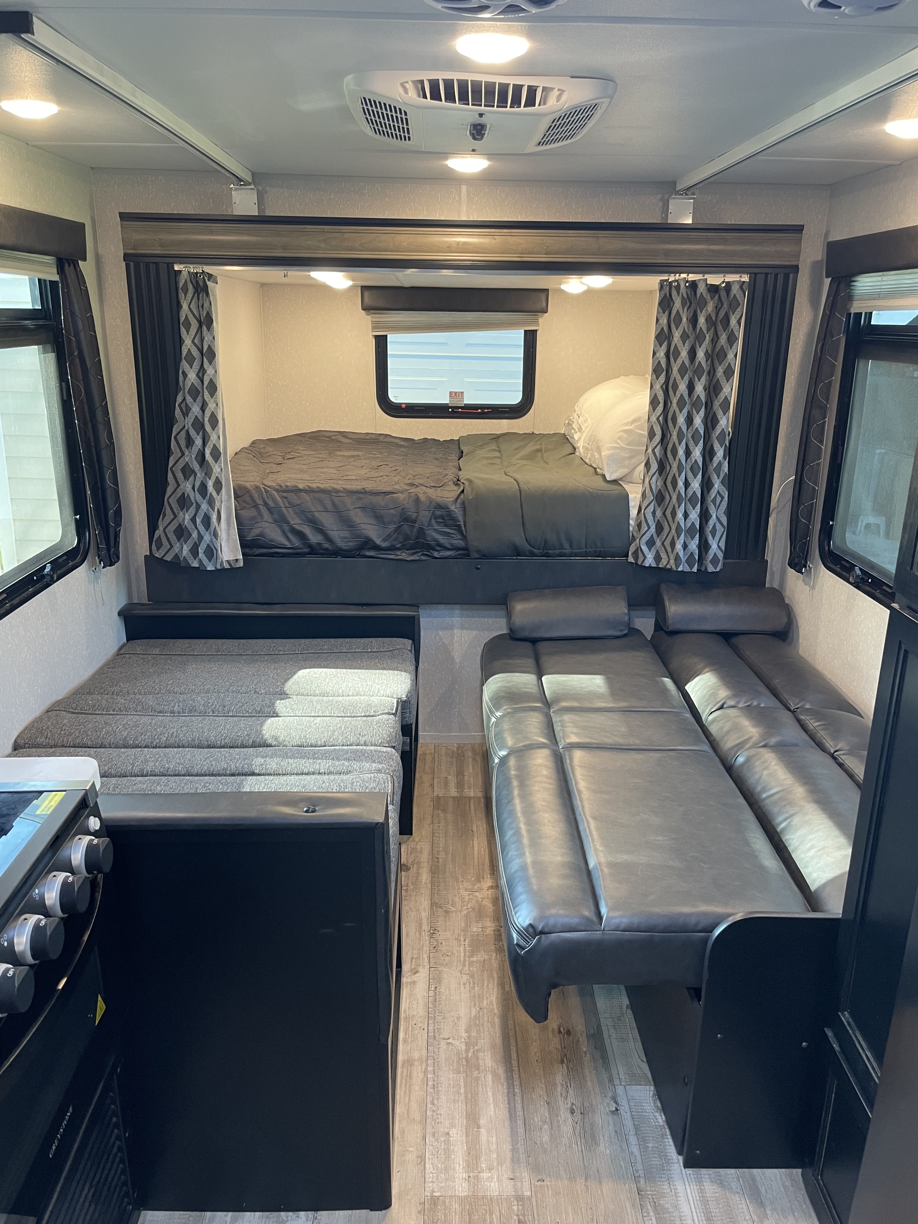 Inside a comfortable RV rental with a rear bed, side sofa, dinette, and kitchen area. Your travel home awaits!. Forest River Cherokee Grey Wolf 2021