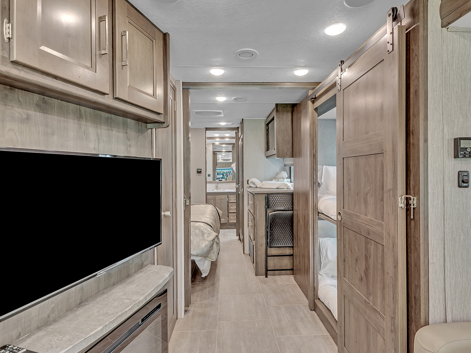 Spacious RV rental interior featuring a bedroom, bunk beds, kitchen, and bathroom for comfortable travel.. Coachmen Mirada 2021