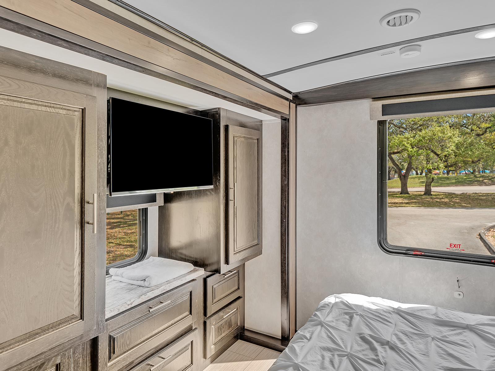 Spacious RV rental bedroom featuring a flat-screen TV, ample storage, and a comfortable bed for your next adventure.. Forest River FR3 2021