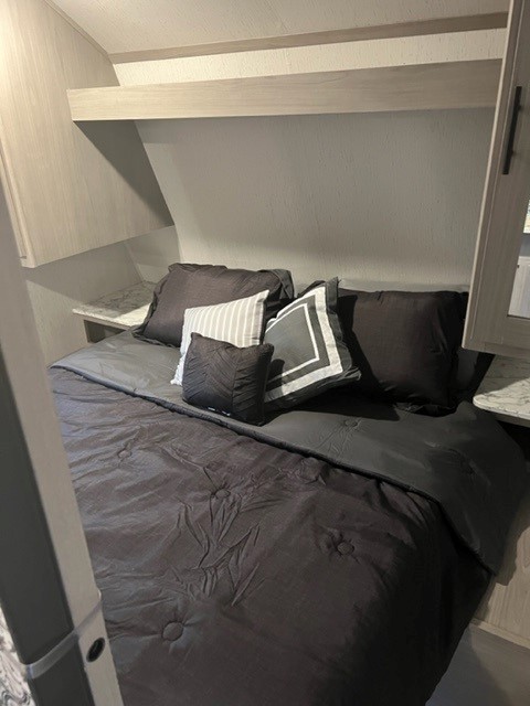 Cozy RV rental bedroom with dark bedding and overhead storage, perfect for your next adventure.. Dutchman Coleman Lantern LT 262BH 2022