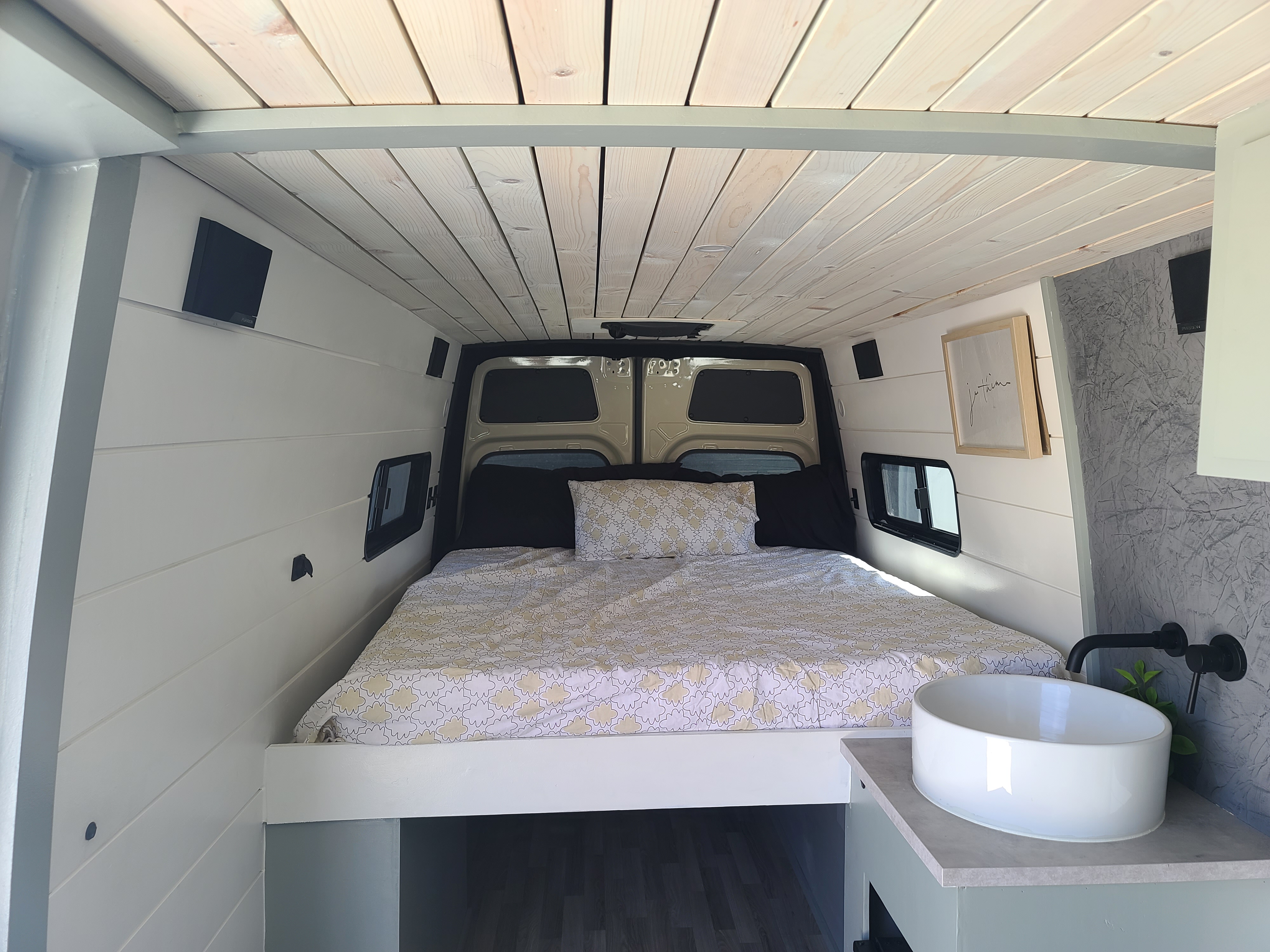 Experience mobile living! This cozy rv rental camper van features a full bed, light wood ceiling, and sleek sink on a counter.. Mercedes-Benz Sprinter RV Motorhome Campervan 2020