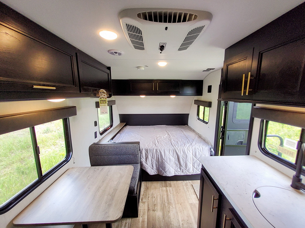 Experience this RV rental! Clean camper interior with a cozy bed, kitchen, and dining space. Ready for your travels.. Forest River Cherokee Wolf Pup 2022