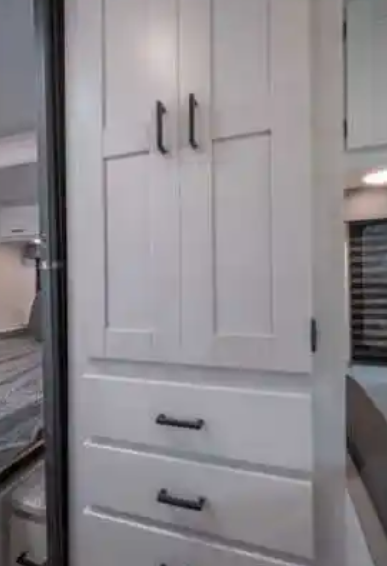Modern RV rental interior with white shaker cabinets and drawers, providing practical storage solutions.. East to West Entrada 2022