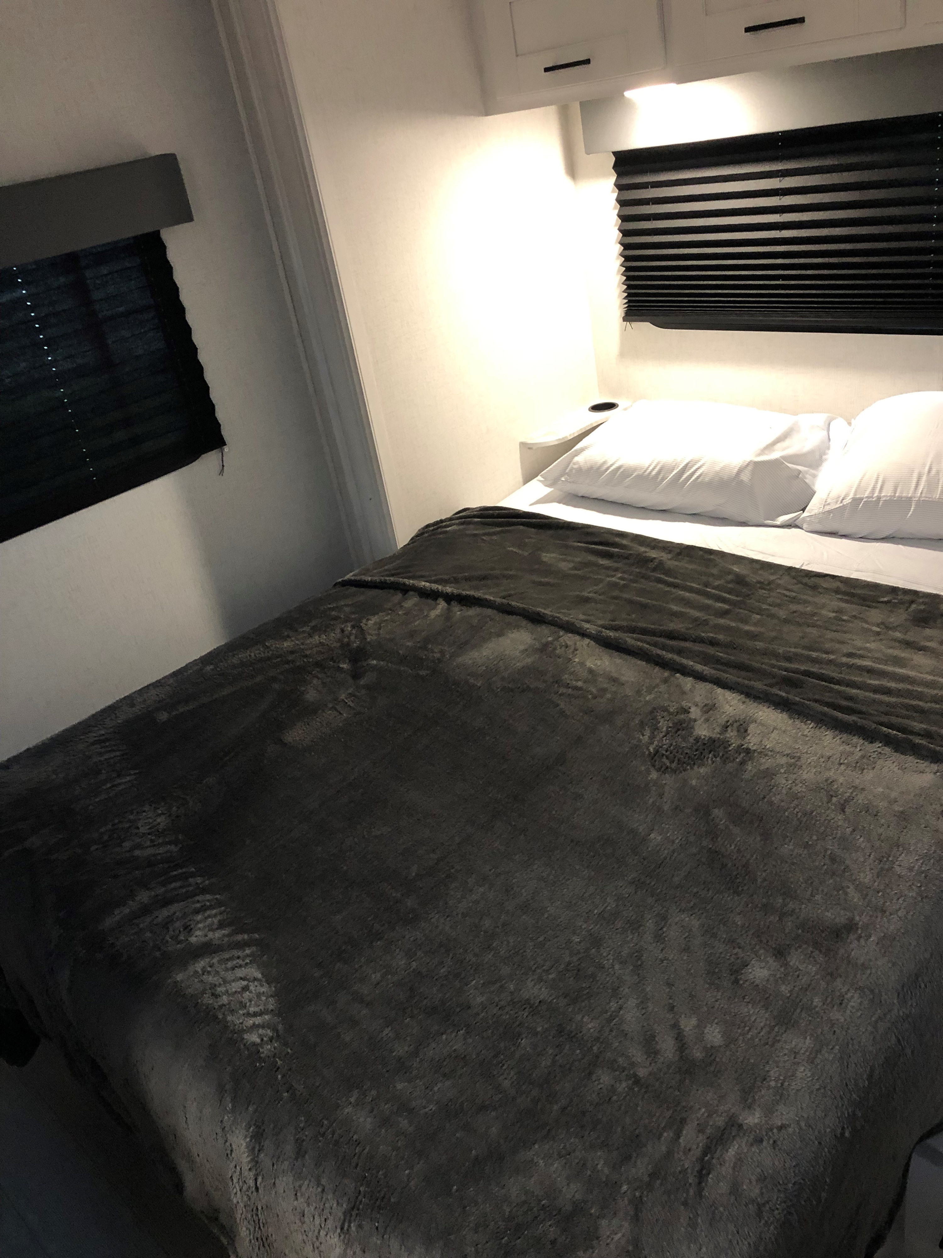 Cozy RV rental bedroom with a plush blanket and built-in storage. Perfect for comfortable travels.. East to West Entrada 2022