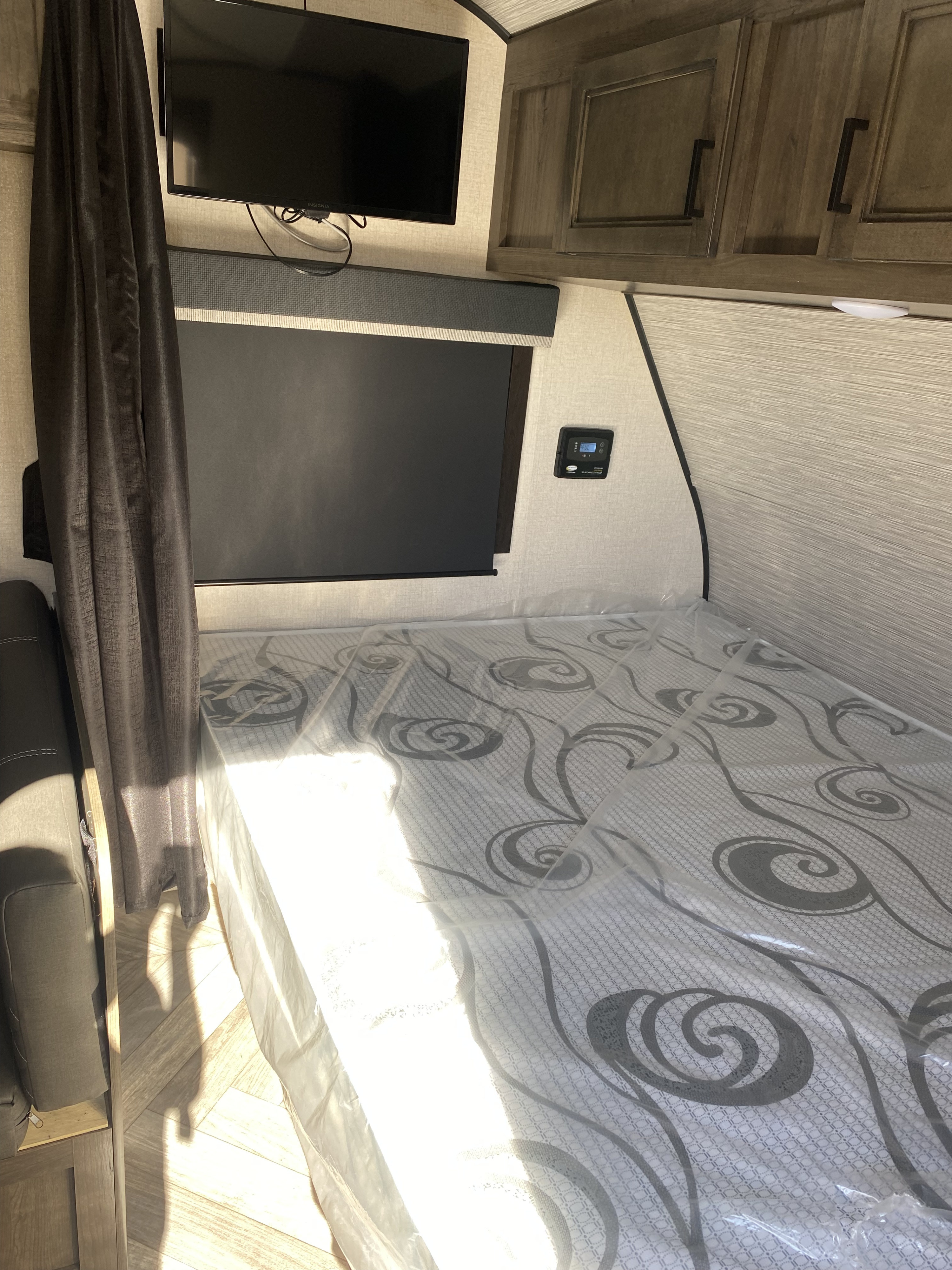 New mattress, TV, and storage in a clean RV rental bedroom.. Highland Ridge RV Olympia 2022