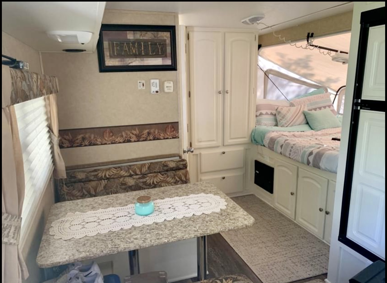 Inside a spacious RV rental: a cozy dining area, pop-out bed with fresh linens, and built-in storage. Ideal for family camping.. Starcraft Travel Star 2009